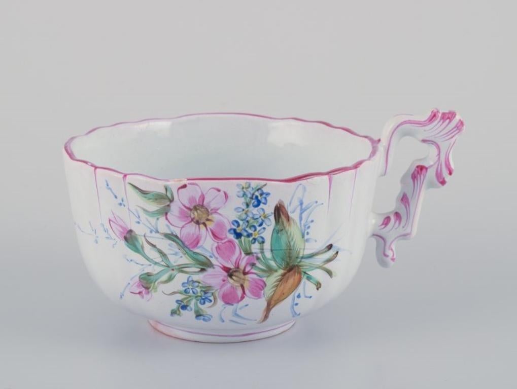 Unknown Three hand-painted tea cups and saucers in faience with motifs of flowers. For Sale