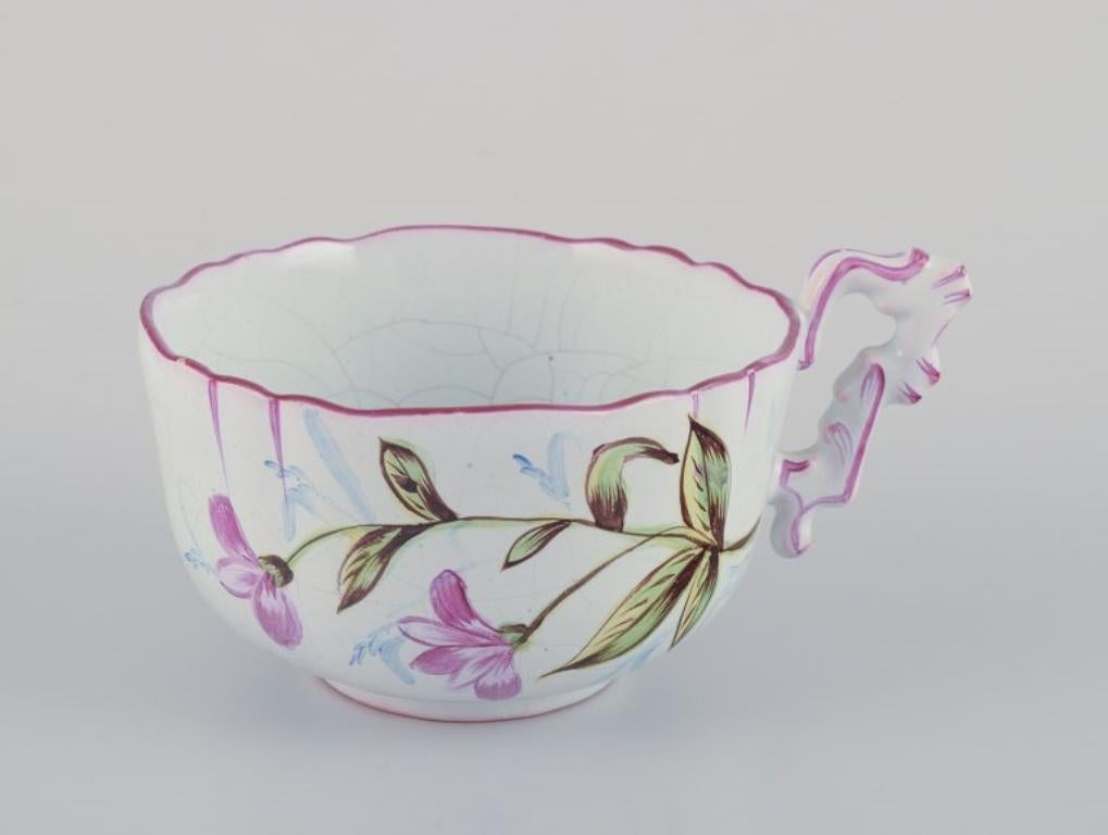 Three hand-painted tea cups and saucers in faience with motifs of flowers. In Good Condition For Sale In Copenhagen, DK
