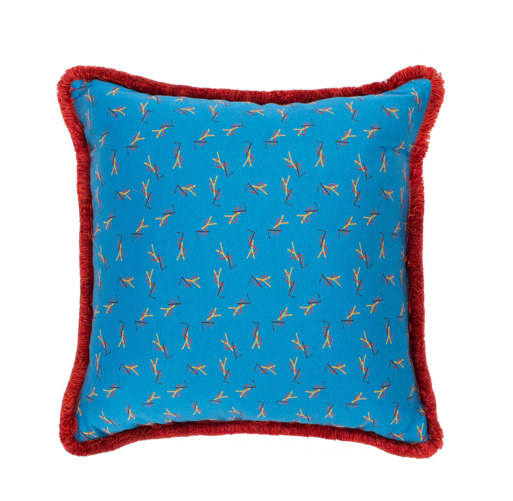 Hand-crafted pillows with front made of beautiful vintage Yves Saint Laurent jersey fabric. It features yellow, red and darkblue logos against a light blue background. Backside in velvet. Fringes in red terracotta cotton. An eclectic style suitable