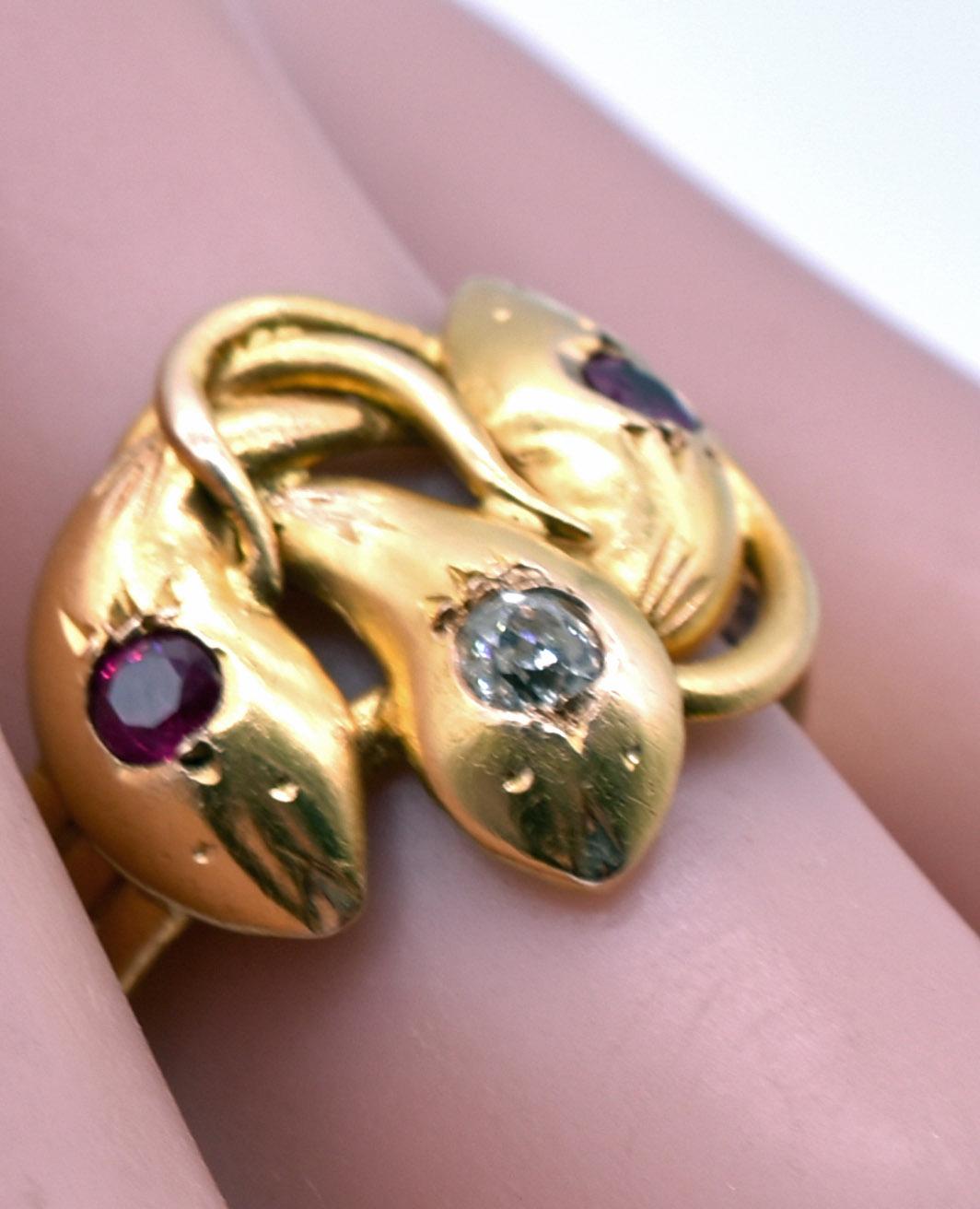18K Snake Ring with a ruby on the two snake of the snake heads and a diamond on the center. The gold band is actually divided into 3 bands set together that wind around the ring.  Everything about this snake ring is wonderful, from it’s symmetrical