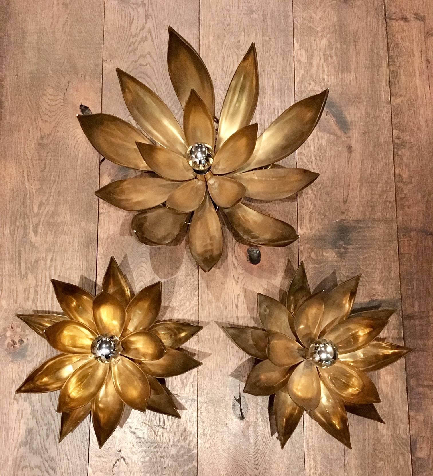 Three very heavy 3D brass wall lights in flower shape. They were made in France in the 1970s. The design is related to designs by Maison Jansen and Maison Charles, but bigger and heavier.

There are two smaller lights with a 40 cm diameter (24 cm