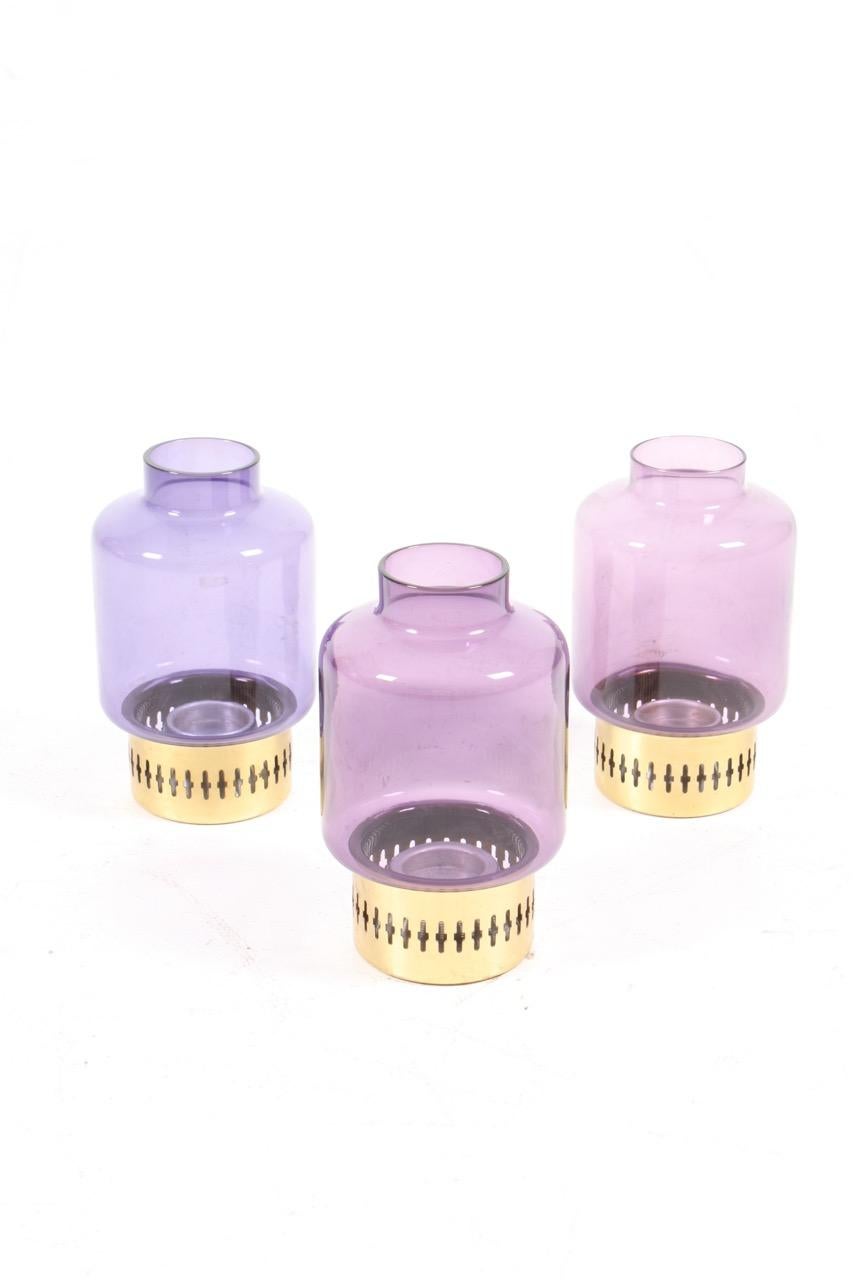 Group of three Hurricanes in brass and purple glass. Designed and made by Hans-Agne Jakobsson AB in Markaryd Sweden in the 1960s. Great condition.