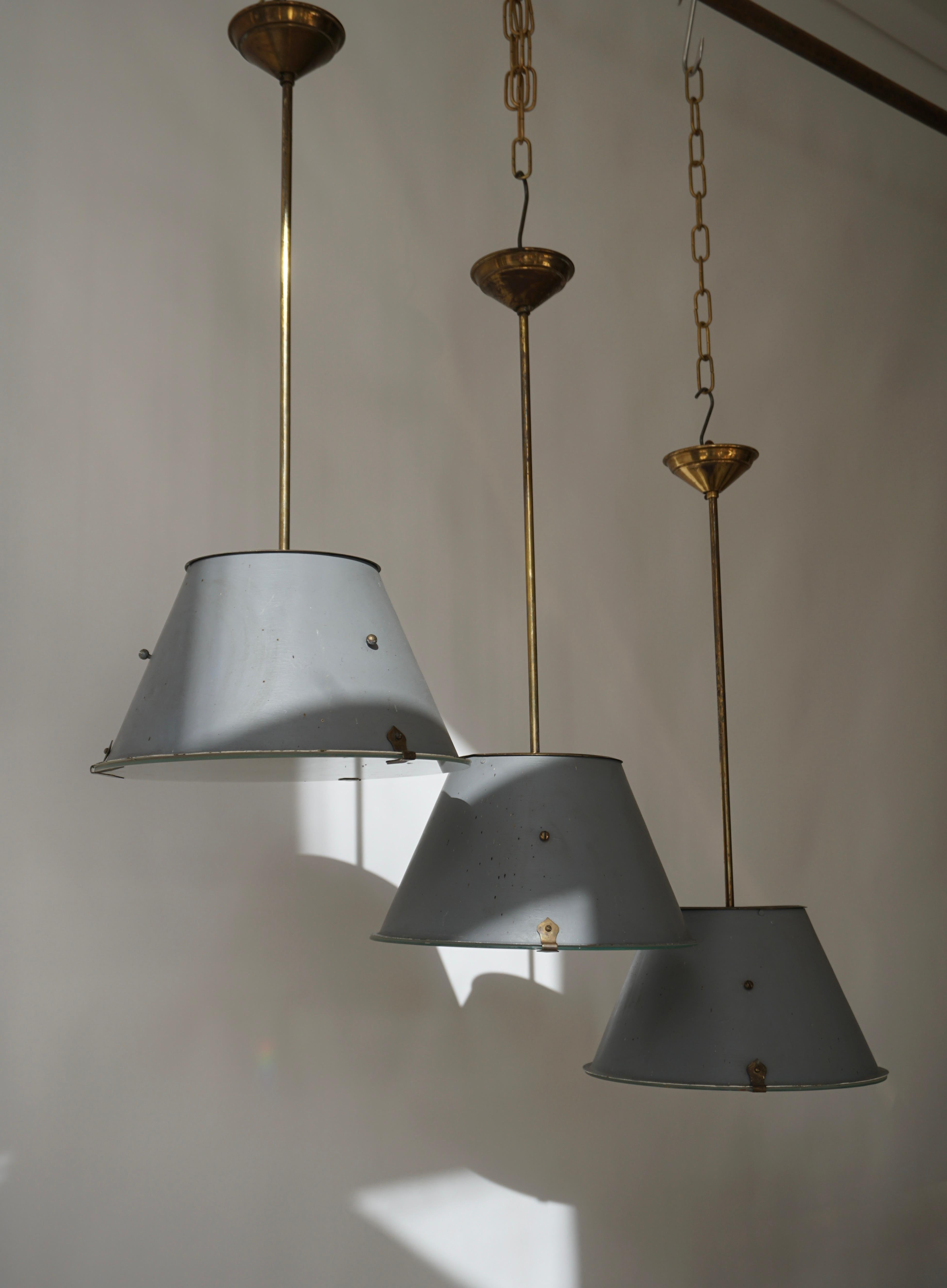 Three industrial Art Deco hanging lamps in glass and painted brass.

Diameter 32 cm.
Height 78 cm.

One E27 light bulb.