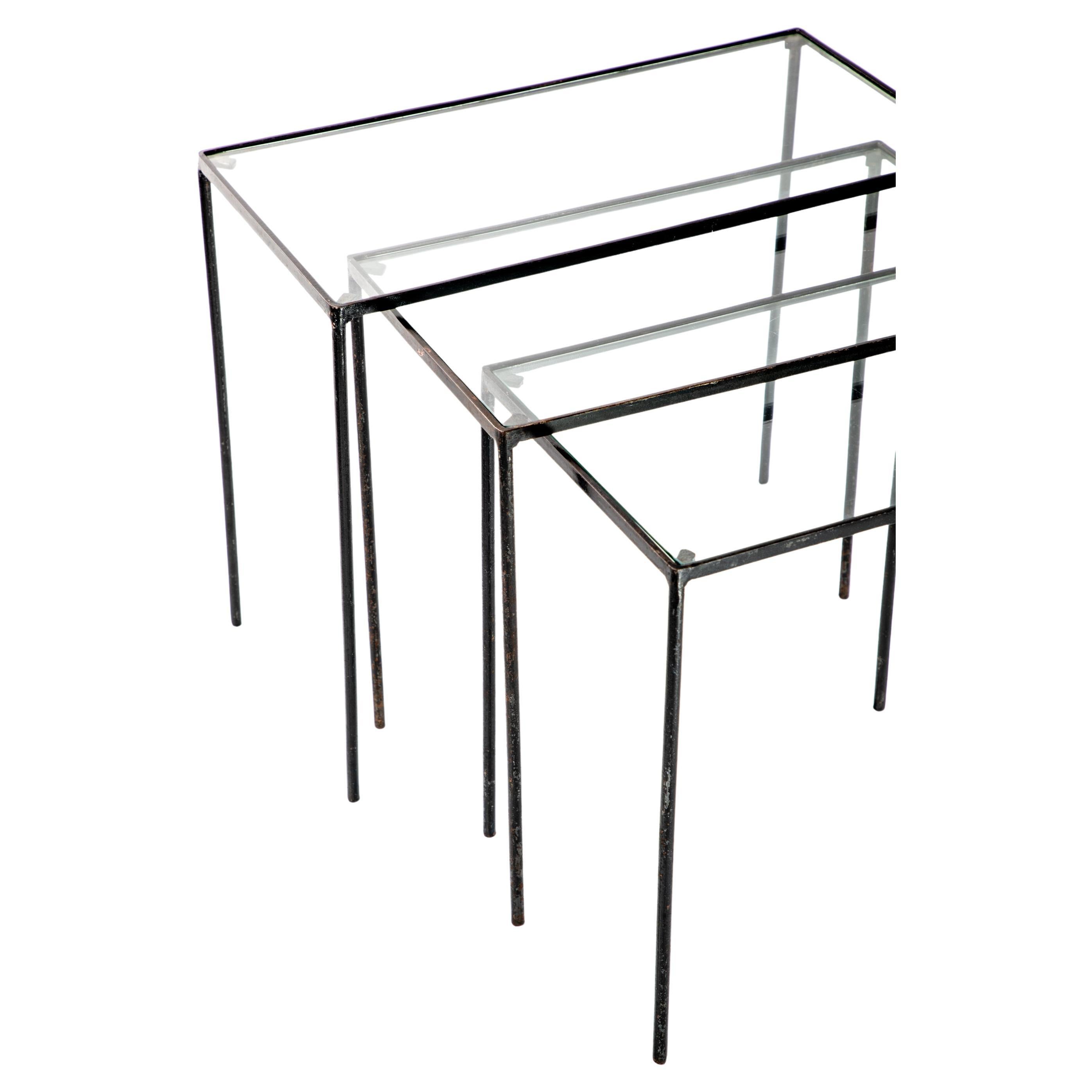 Set of three nesting tables in the manner of Jean-Michel Frank.  Iron and glass, round legs.  

Dimensions:
Lg table - 20
