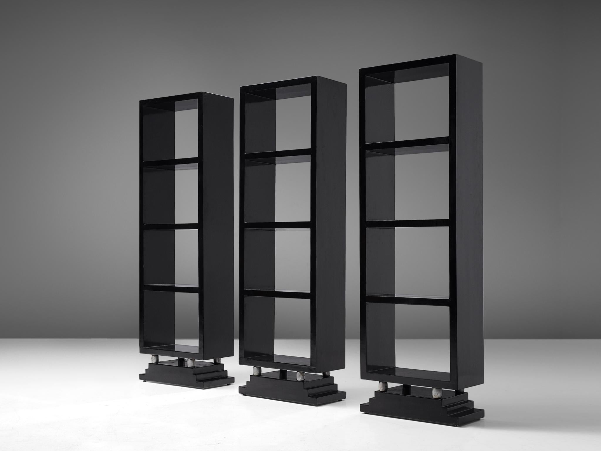 Set of 3 bookcases in the style of Osvaldo Borsani, black lacquered wood and metal, Italy, 1930s.

Elegant black lacquered bookcases, consisting of three narrow elements. With its thick, high gloss lacquered lines the pieces have a graphical