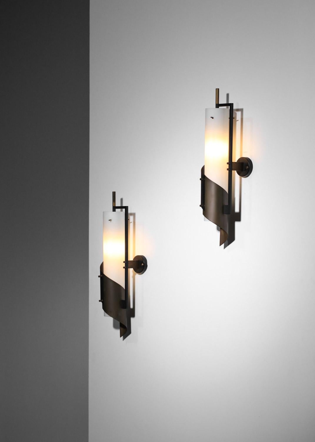 Set of three 60's Italian wall sconces in the Stilnovo style. Structure in black lacquered metal and solid patinated brass. Shades in opaque white opaline. Very fine work with rigitulle and brass plates on the front of the sconce. Very fine vintage