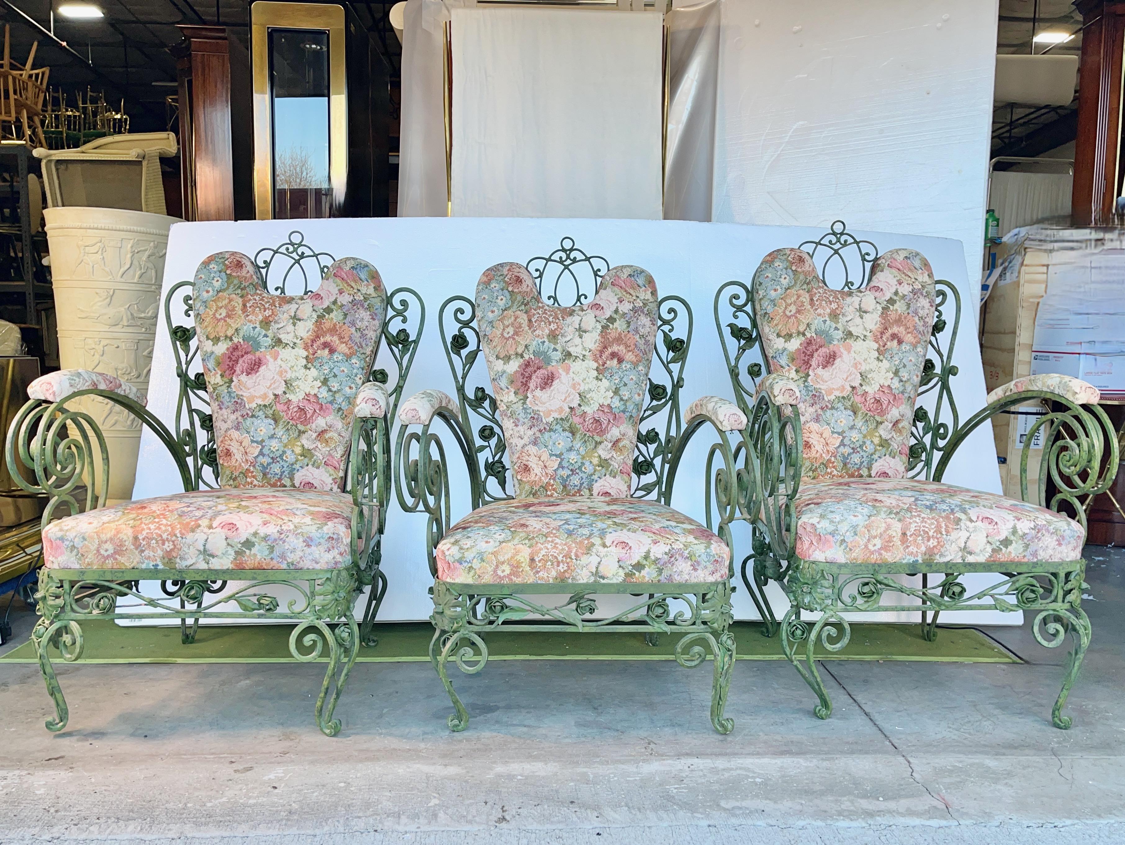 Three Italian wrought iron oversized patio chairs with upholstered seats, backs and armrest pads. 
Note the distinctive iron rosebuds, stems and leaves among the iron scrolls.
Original mottled green baked enamel finish.
The original weather