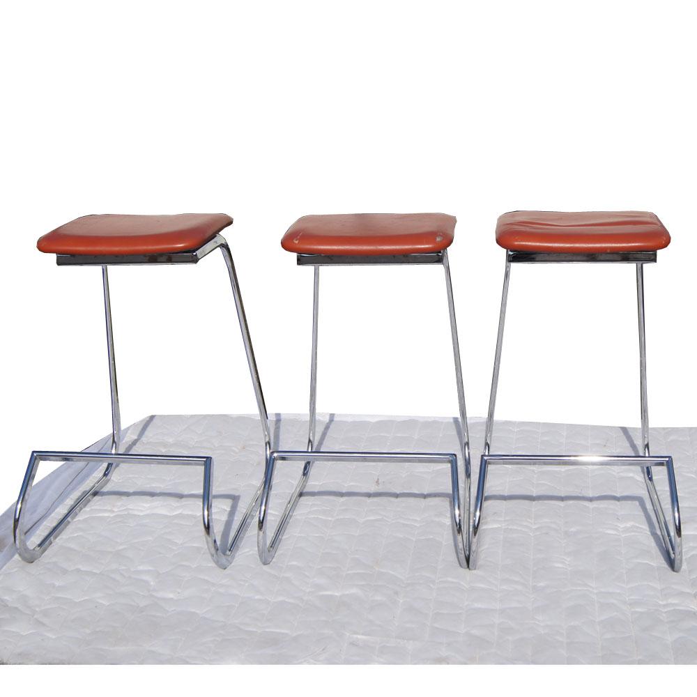 A set of three mid century modern Prometheus stools designed by John Behringer and made by Stendig with chrome bases and the original vinyl upholstery.