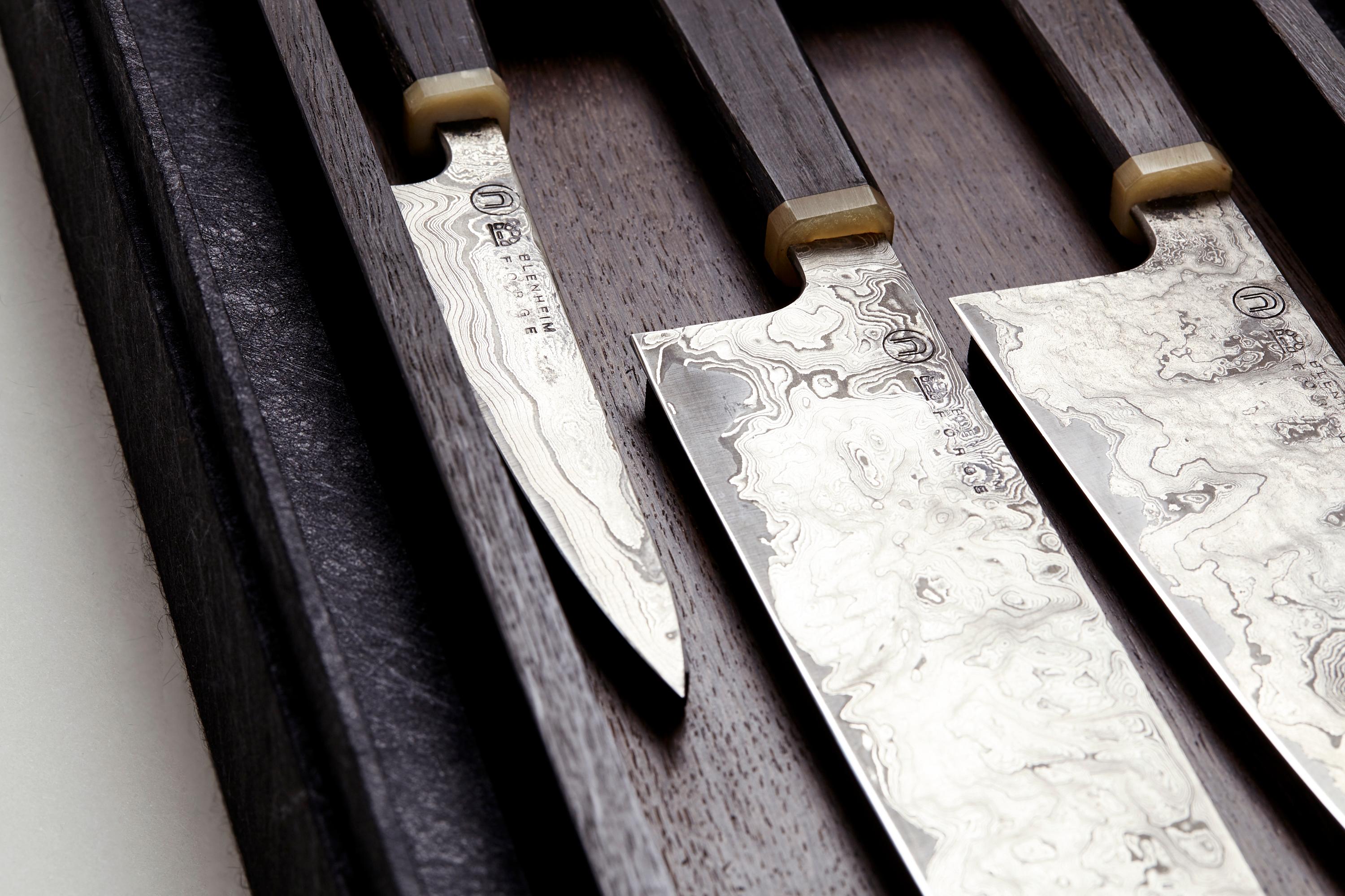 Le premier projet de DOVEDALE est un ensemble de couteaux en acier damassé d'inspiration japonaise. Les lames d'acier en papier bleu plié sont placées dans des manches en bois et disposées dans un coffret de présentation, tous deux fabriqués en