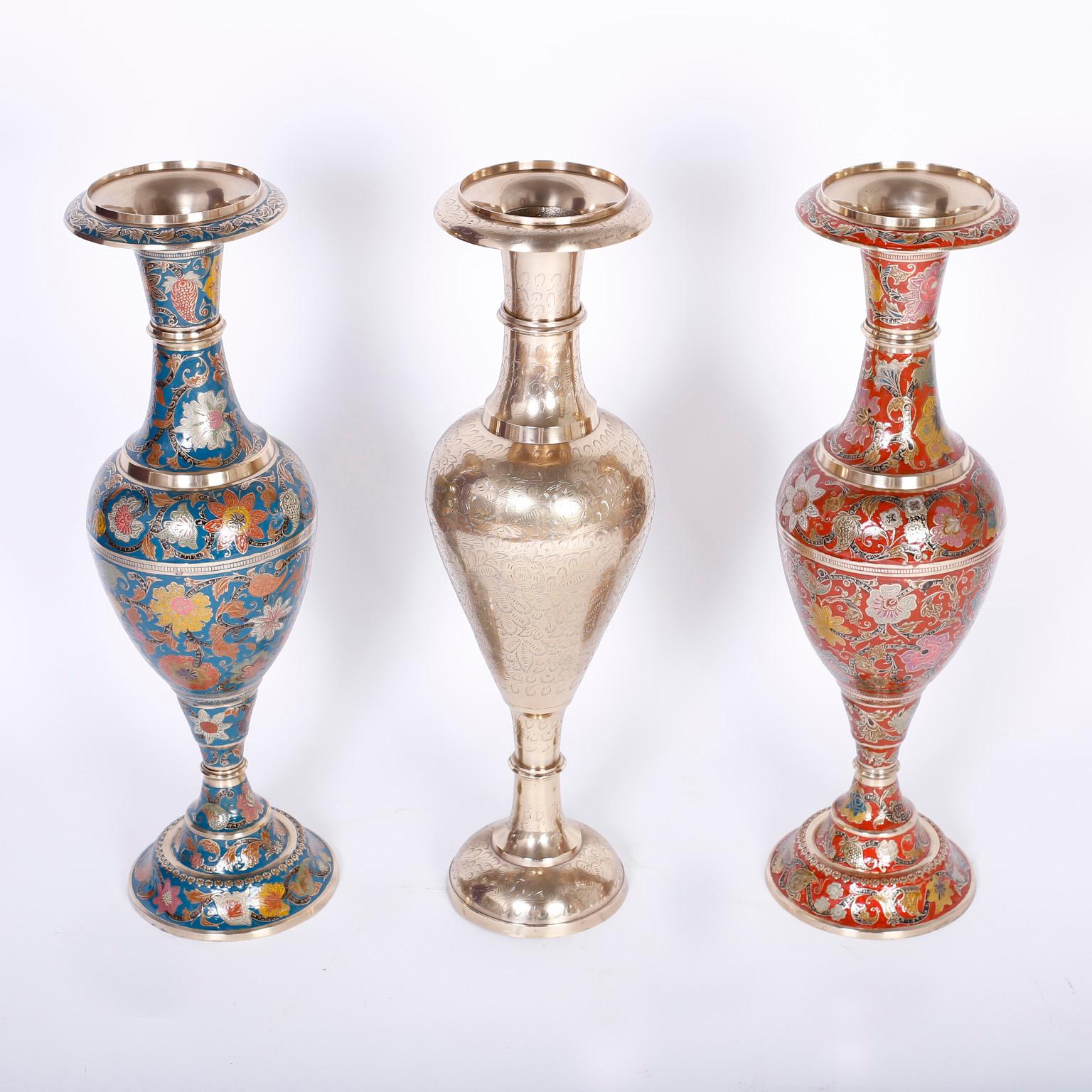 Here are three Anglo-Indian tall dramatic vases or urns crafted in spun brass and hand etched or inscribed. The left and right urns are hand decorated with enamel in lovely floral designs. All three are hand polished and lacquered for easy care.
   