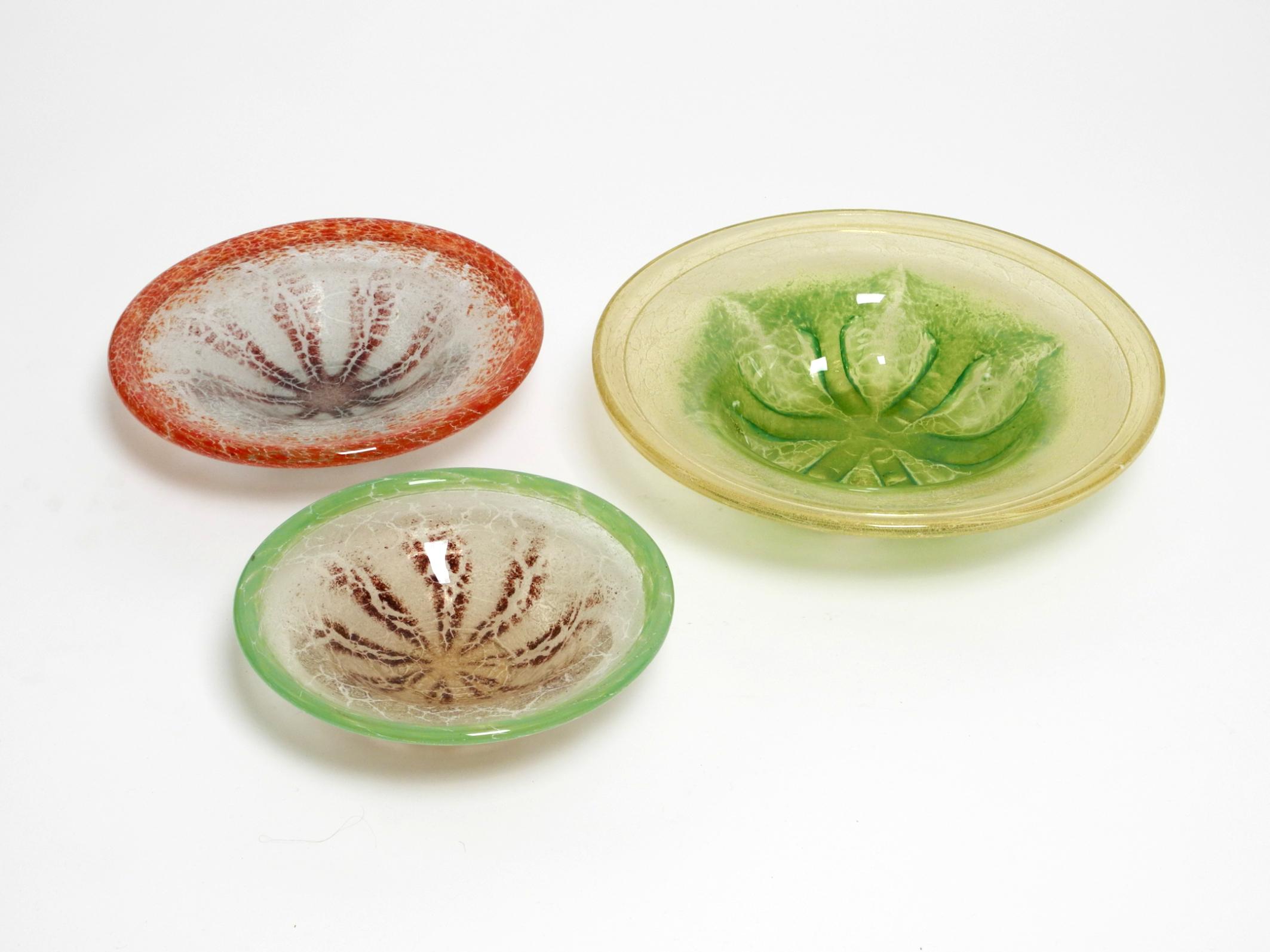 Drei schöne große Tischschalen aus Glas von Karl Wiedmann.
Hergestellt in den 1930er Jahren von WMF Ikora. Hergestellt in Deutschland.
Diese WMF-Klassiker werden hier in drei verschiedenen Größen präsentiert.
Alle drei Glasschalen sind in sehr gutem