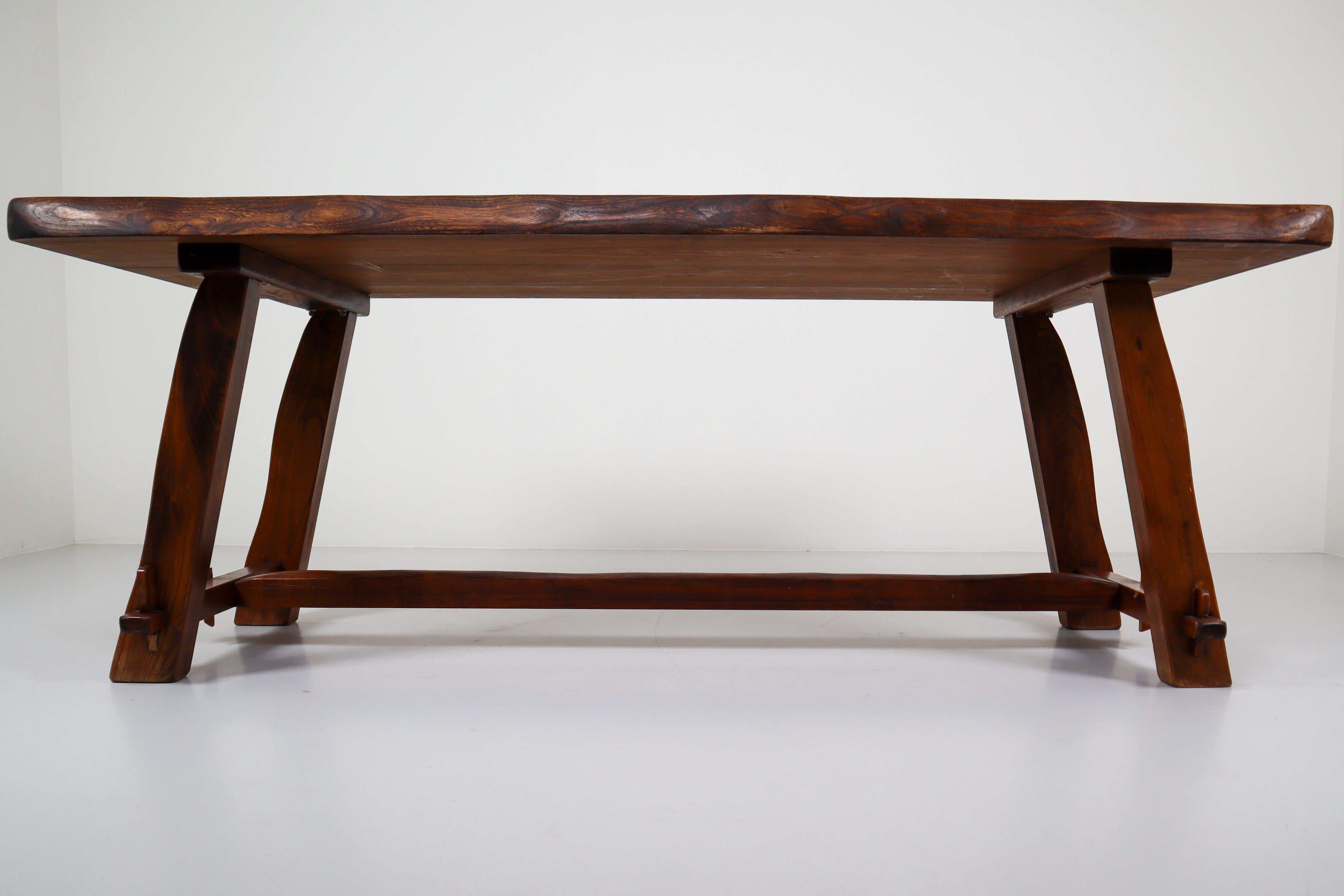 This table is made of stained elm wood and sculpturally crafted by hand very minimalistic, yet Brutalist shaped and in very good original condition. Its generous dimensions of 200 cm by 90 cm can accommodate up to 8 people each table. Very good