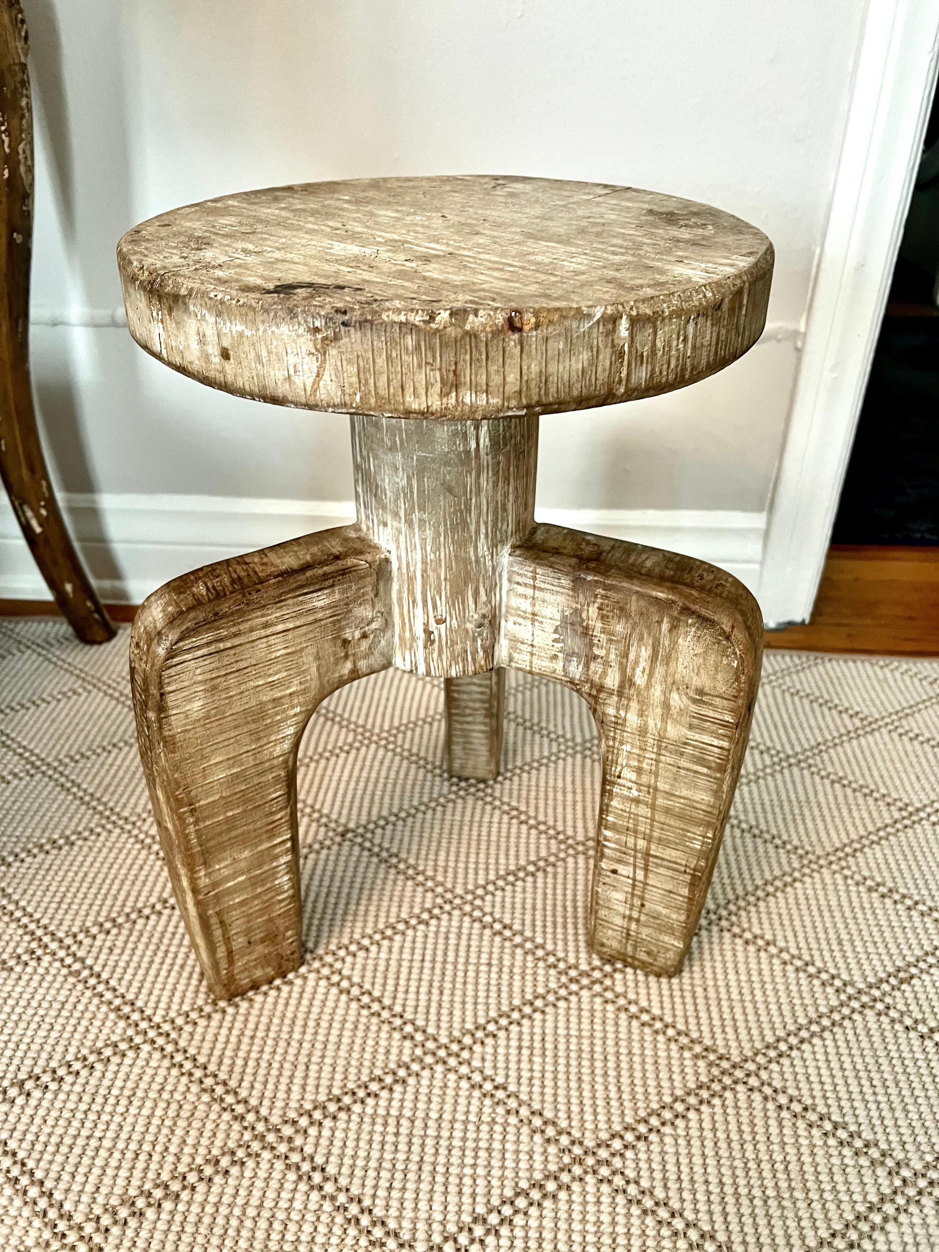 A uniquely designed three legged stool or side table in a washed cerused finish of organic white The legs sit upon a column for the seat - a compliment to any setting with a neutral or organic feel. 

Can easily be placed under a console or behind