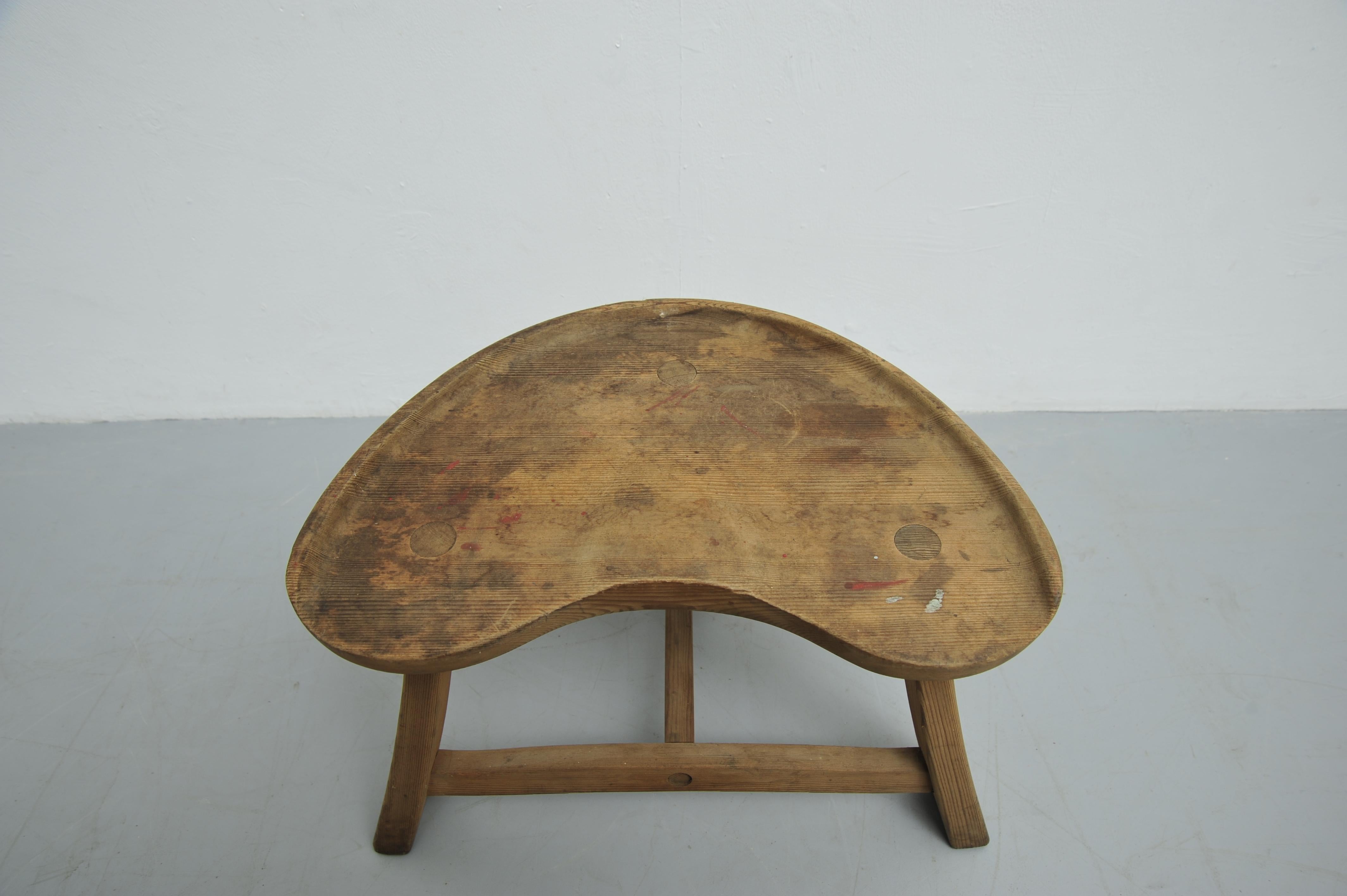 The Fjøskrakk Model 522 stool was designed by Ragnvald Krogenæs and produced by Krogenæs Møbler in Norway in the 1960s. Made of solid pine, it features a carved tractor-style seat on three splayed legs connected with T-form stretchers. The simple