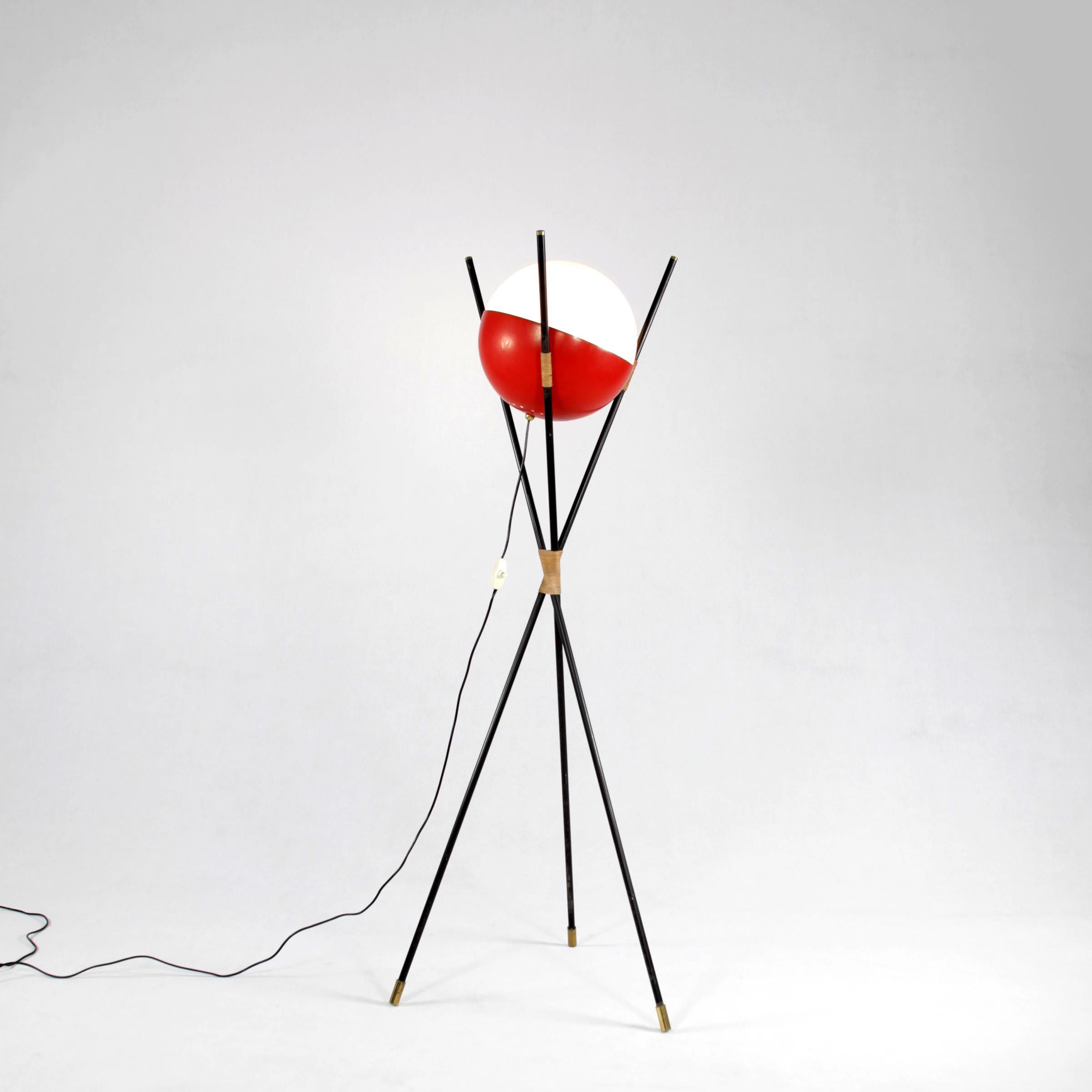 Three-legged lamp, design and manufacturing by Stilnovo, Italy, 1950s. The lamp has a lacquered metal framework, glass sphere and red lacquered aluminium shade.