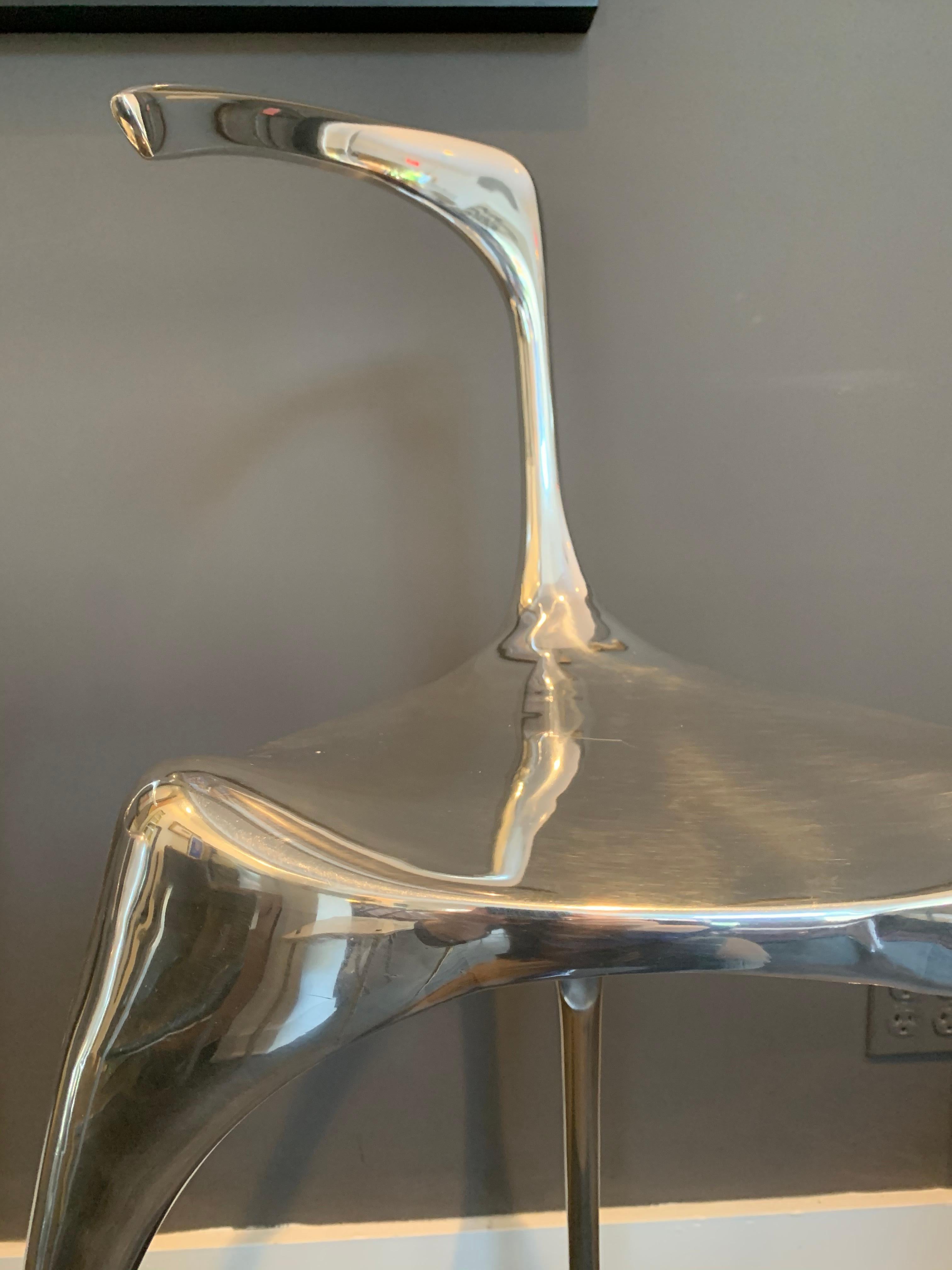 This is a pair of mirror finish polish liquid style and very modern looking bar stools. A floating foot rest and jetting out back rest. Beautiful from all sides.