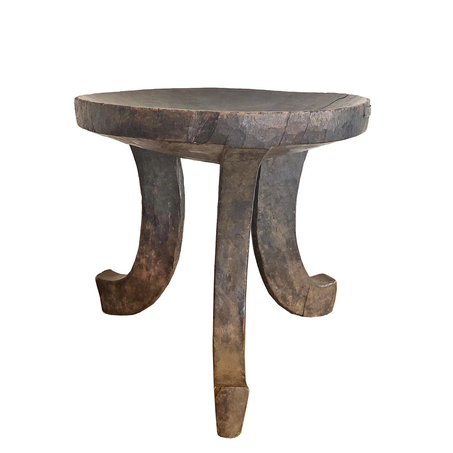 Tabouret ou siège africain à trois pieds, sculpté à partir d'une seule pièce de bois, attribuable au peuple Oromo dans ou autour de la ville de Jimma en Ethiopie. Ce tabouret était un objet utilitaire utilisé dans la vie quotidienne des tribus et