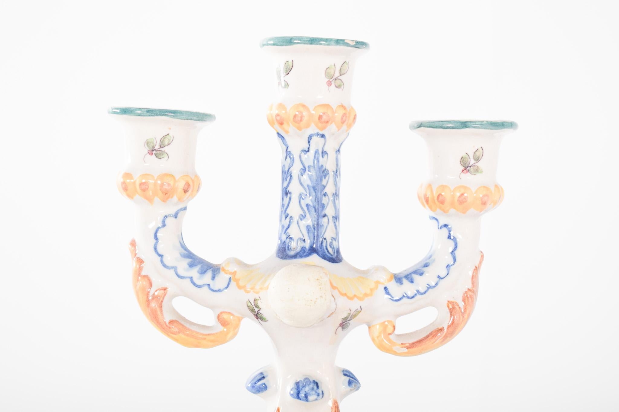 Three-light candelabra, in Portuguese faience. Polychrome decoration, raised central body and two symmetrical side arms, forming a balanced set with three candle holders. The decoration is rich in hand-painted floral and plant elements, with bright