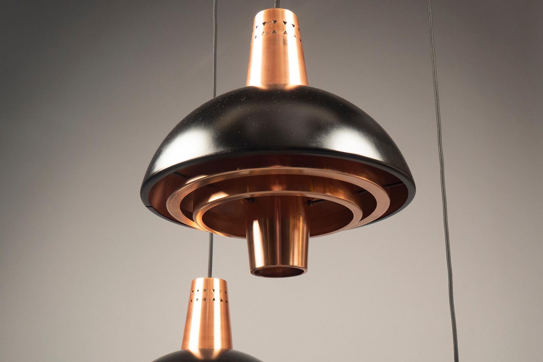 Each light composed of a copper structure with a partially black panted shade suspended from a Rayon cord. Original Stilnovo stickers. 
Non-UL wired for the US.