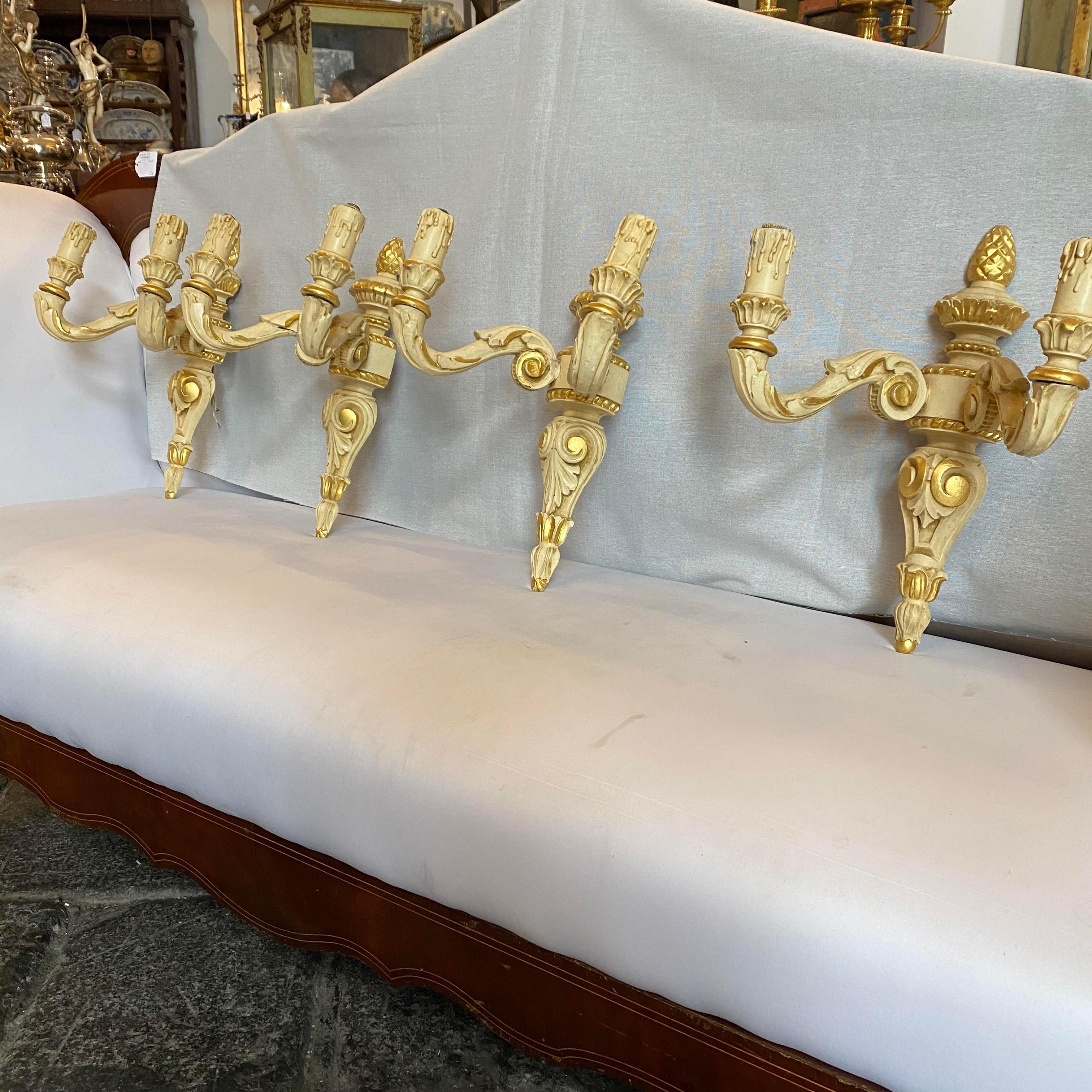 A pair of antique ivory and gold lacquered wood hand-crafted in Italy in the first half of 20th century.