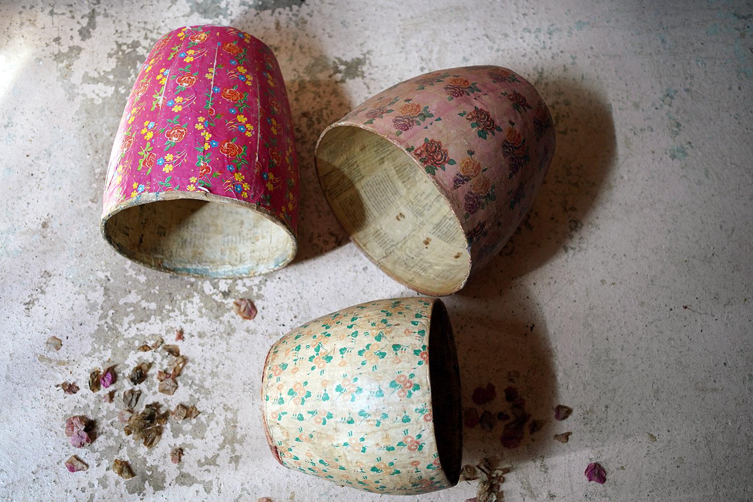 The marvellously colourful trio of papier-mache baskets or pots, having floral rose themed exteriors in differing shades of pink and ivory, the interiors with newspaper cuttings, each surviving from mid-century China.

Remaining in good overall