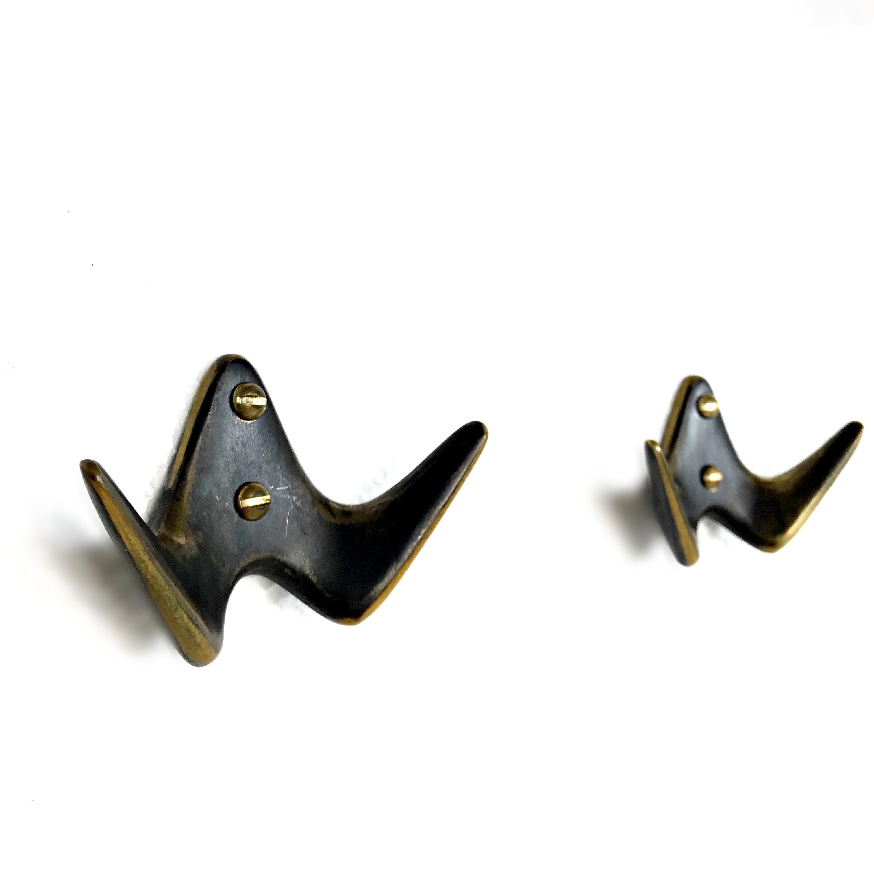 Beautiful Austrian Mid-Century Modern solid brass hooks by Carl Auböck II from 1950s. They are made of polished and patinated solid brass and come with the original brass screws. In excellent original condition. We also have the matching big hooks