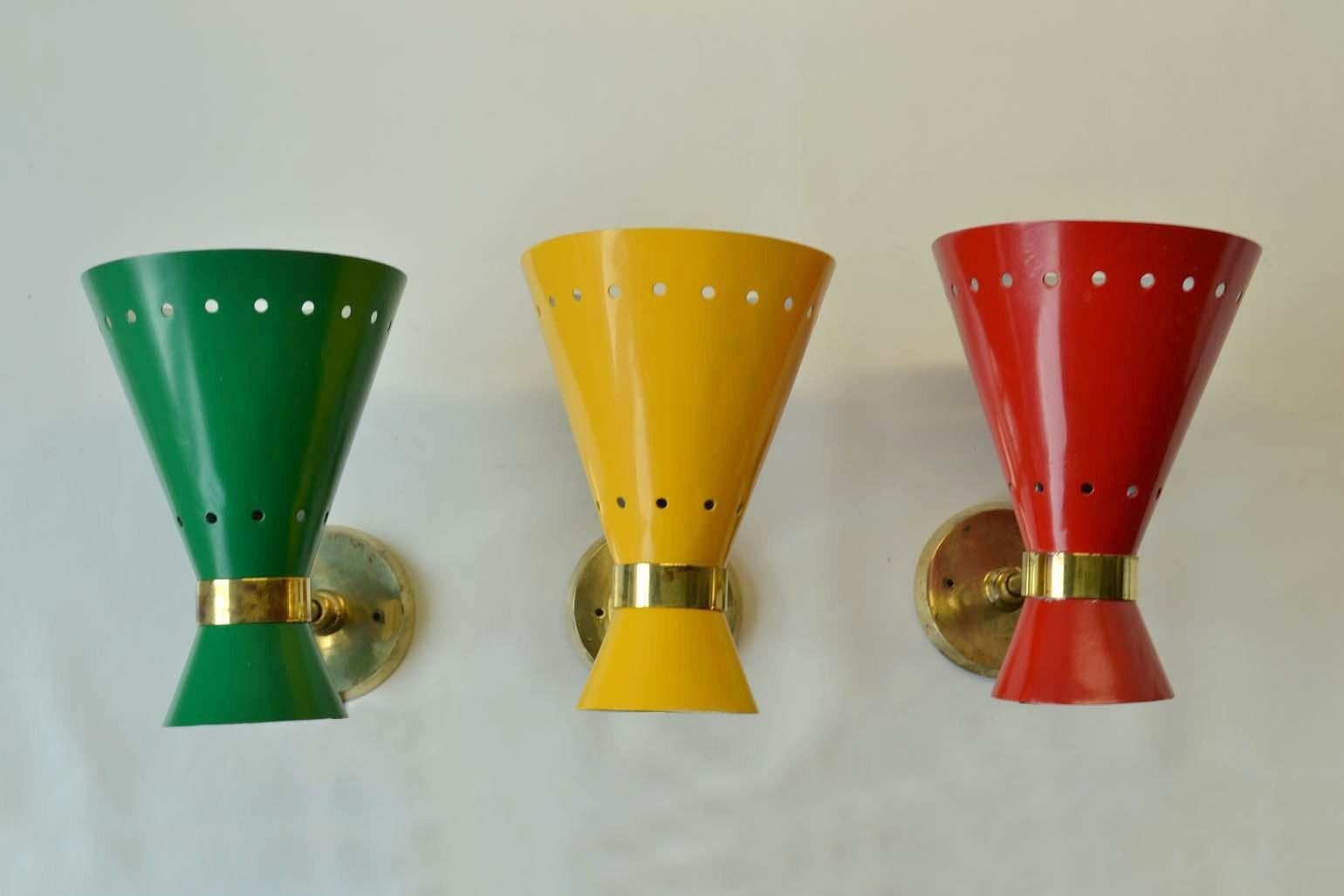 Three original Mid-Century Modern Italian red yellow & green enameled aluminum & brass hourglass shape sconces with adjustable joints to angle the light source. These Italian enameled sconces attributed to Stilnovo were produced in the 1950s-1960s