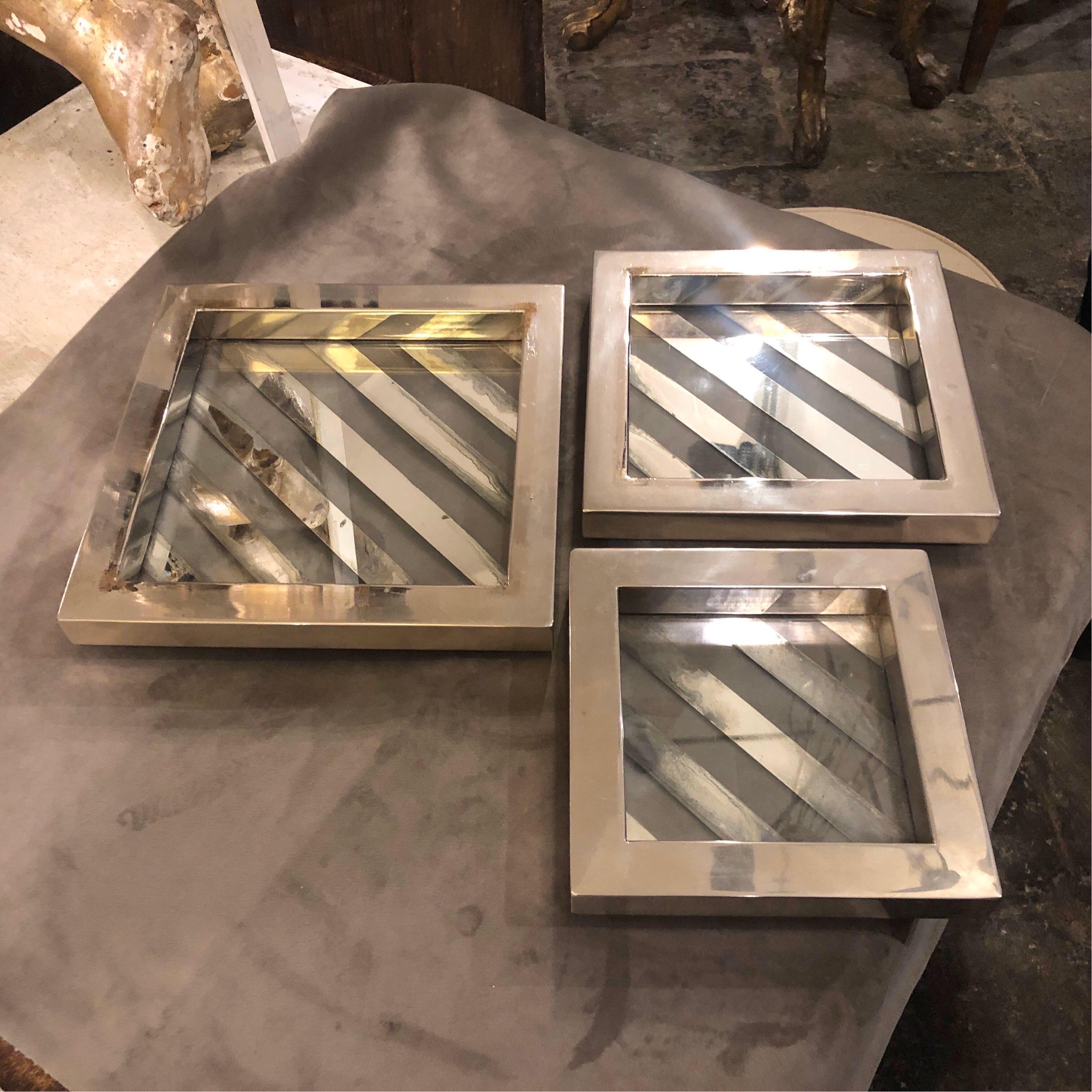 Three Minimalist stacking trays in polished metal and glass attributed to Romeo Rega. Medium side dimensions is 21 cm, small side dimension is cm 18. They are in original conditions, some signs of use and age on the metal visible on the photos