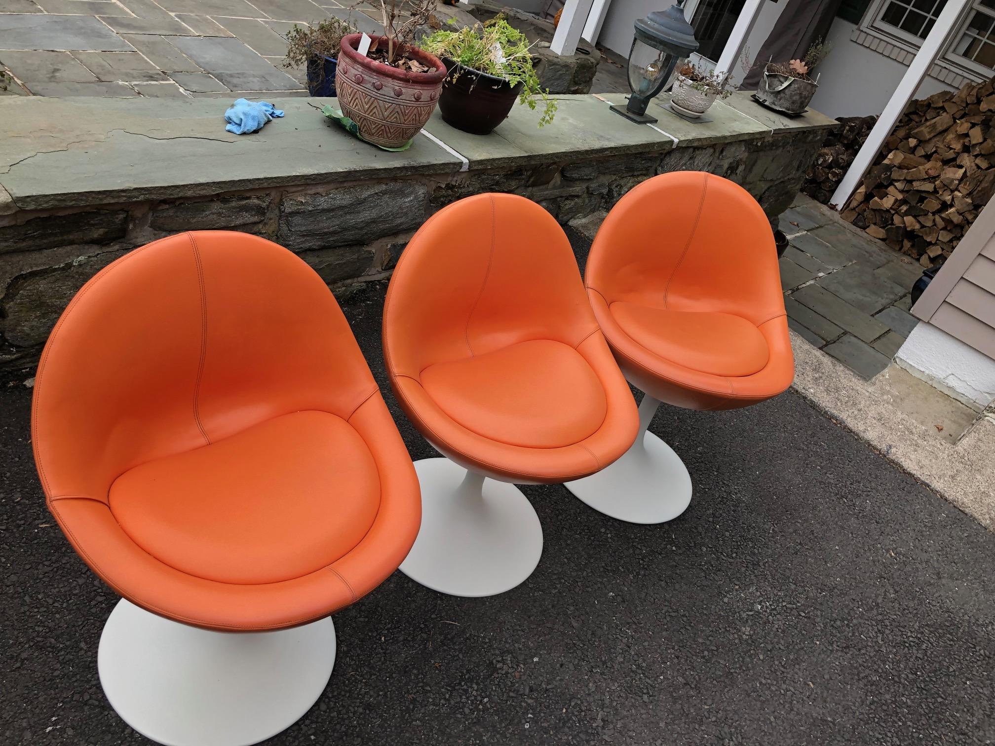 Johanson Design, Sweden; orange vinyl upholstered swivel seats, painted metal tulip base, 29 in. H., 20 1/2 in. W., 19 in. D., base - 16 in. diameter.