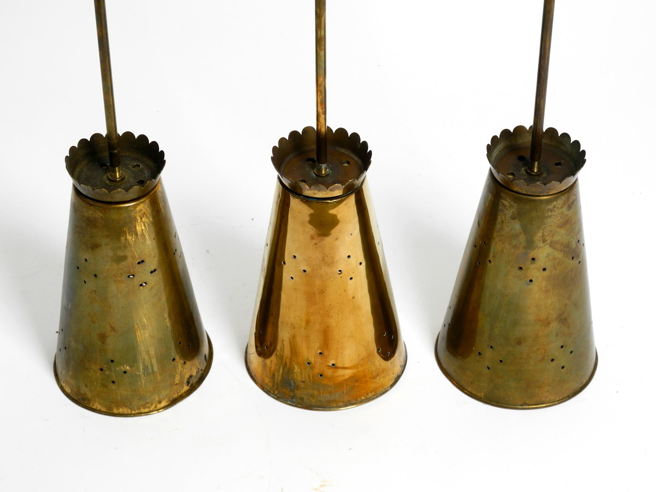 Three Mid Century pendants with a diabolo design in perforated sheet brass 12