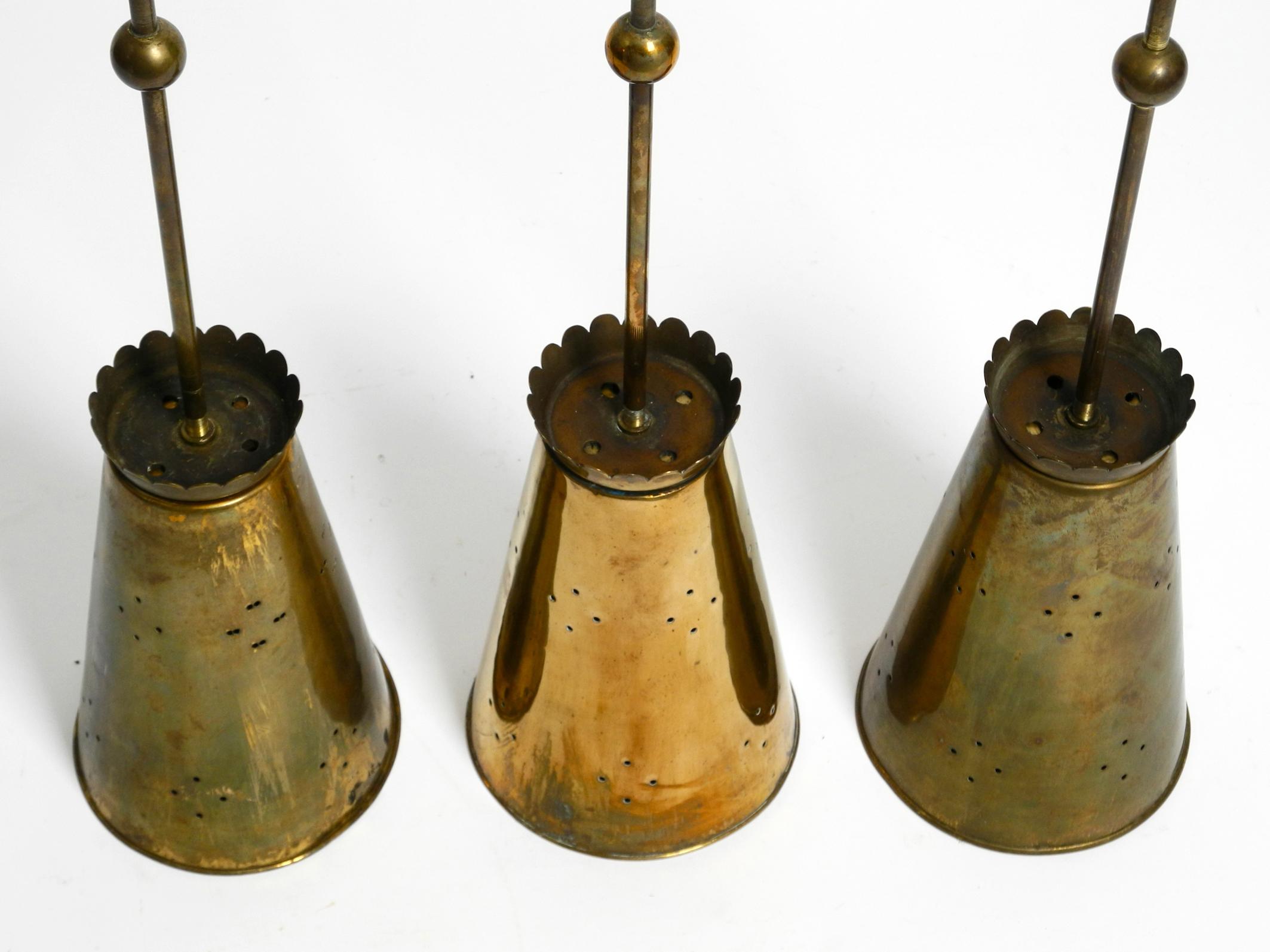 Three Mid Century pendants with a diabolo design in perforated sheet brass 13