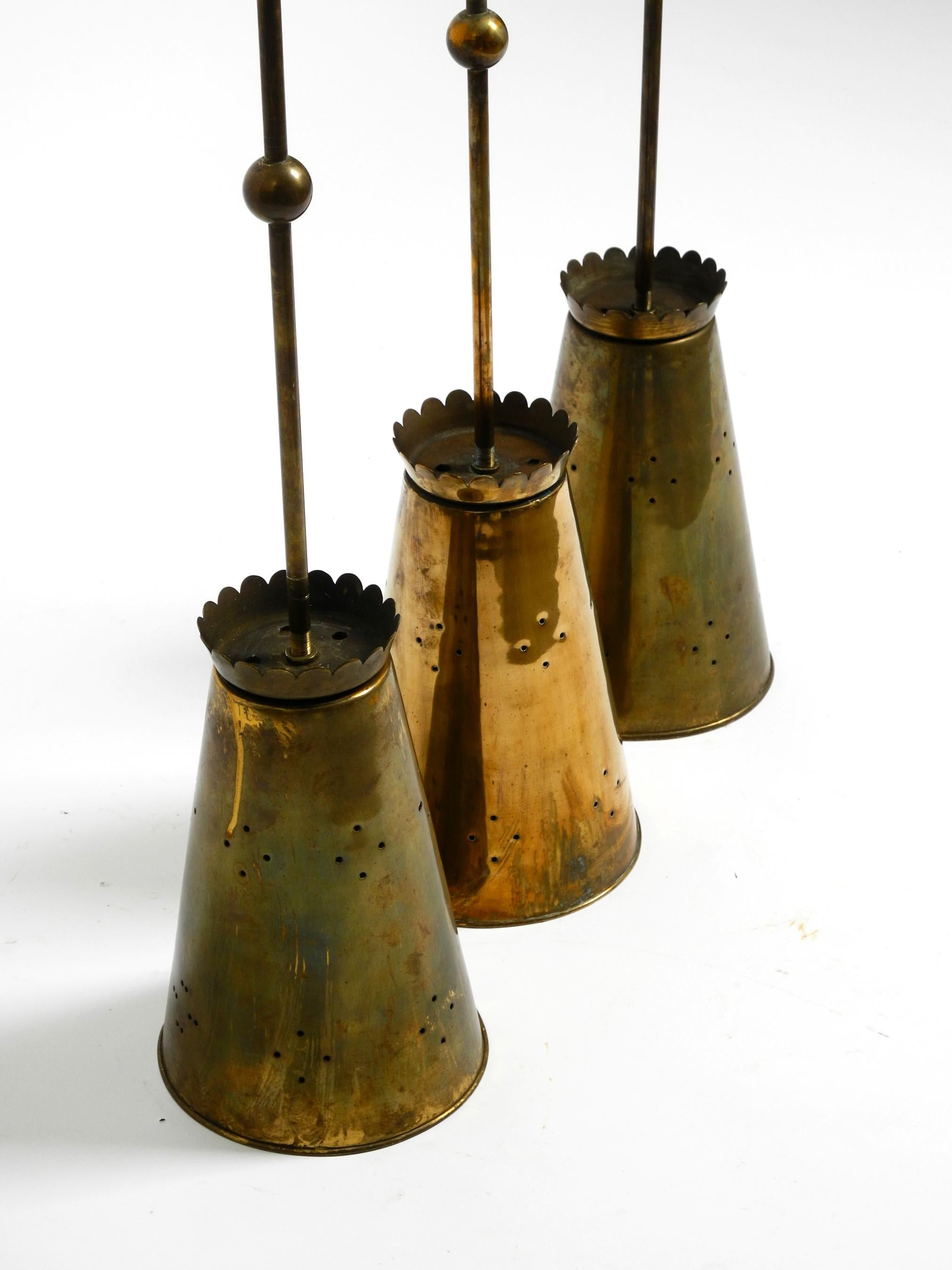 German Three Mid Century pendants with a diabolo design in perforated sheet brass