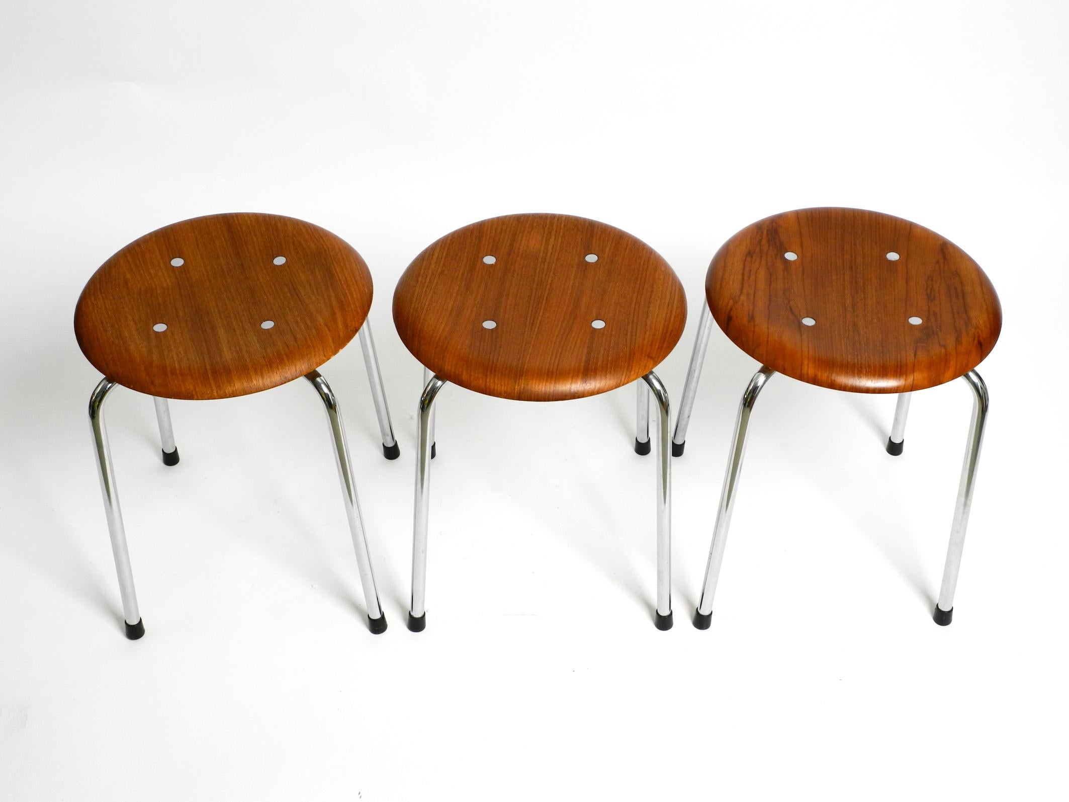 Three original Mid-Century Modern four-legged stackable teak stools. 
SE 38 by Egon Eiermann for Wilde + Spieth.
Egon Eiermann was an important world famous German post-war architect and furniture designer.
These stools were manufactured in the