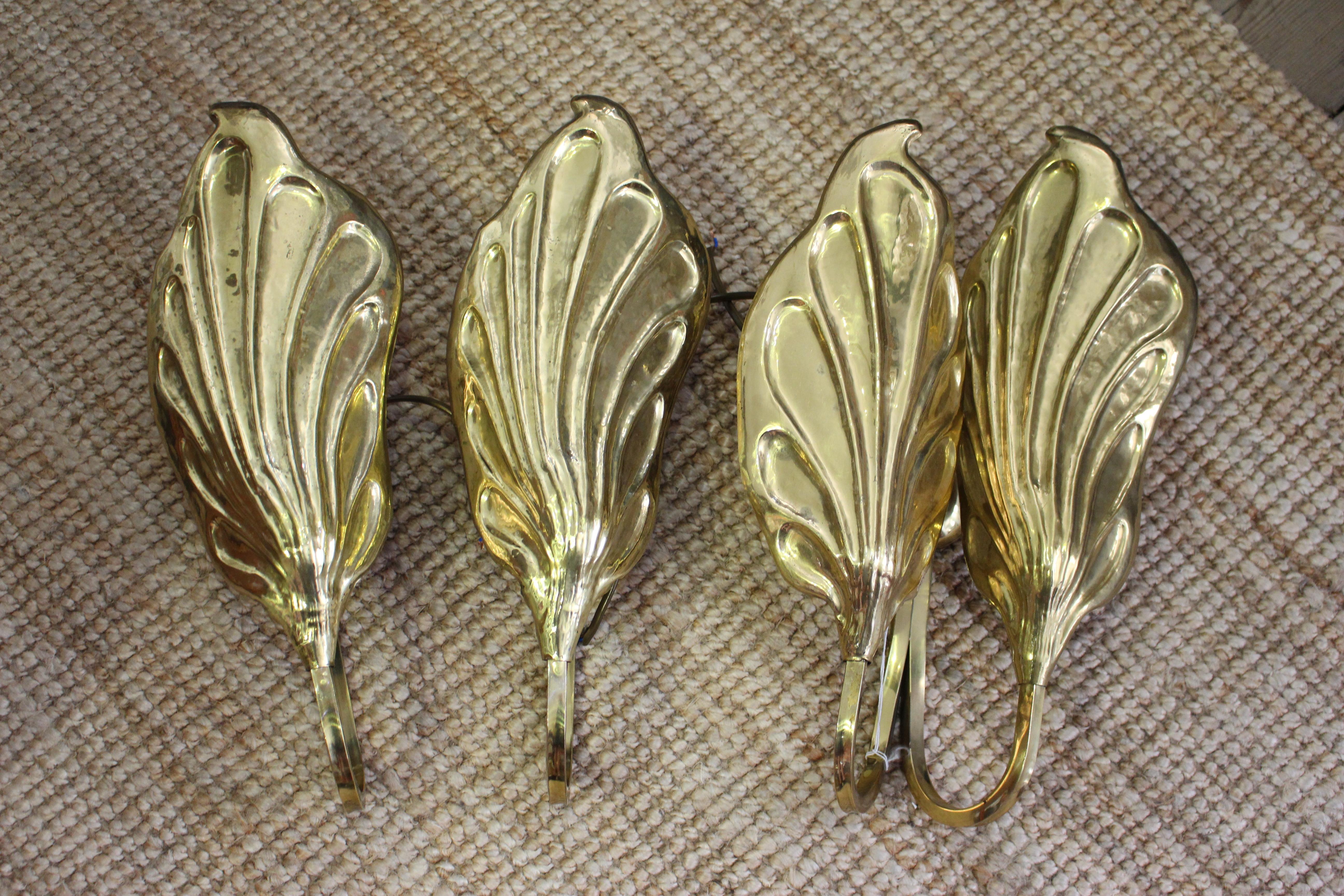 A set of three Italian wall lights by Tommaso Barbi, circa 1970applied labels inscribed G &G Studio Disegni, solid brass hand shaped brass fittings, the shades in the shape of leaves, with light fitments.
