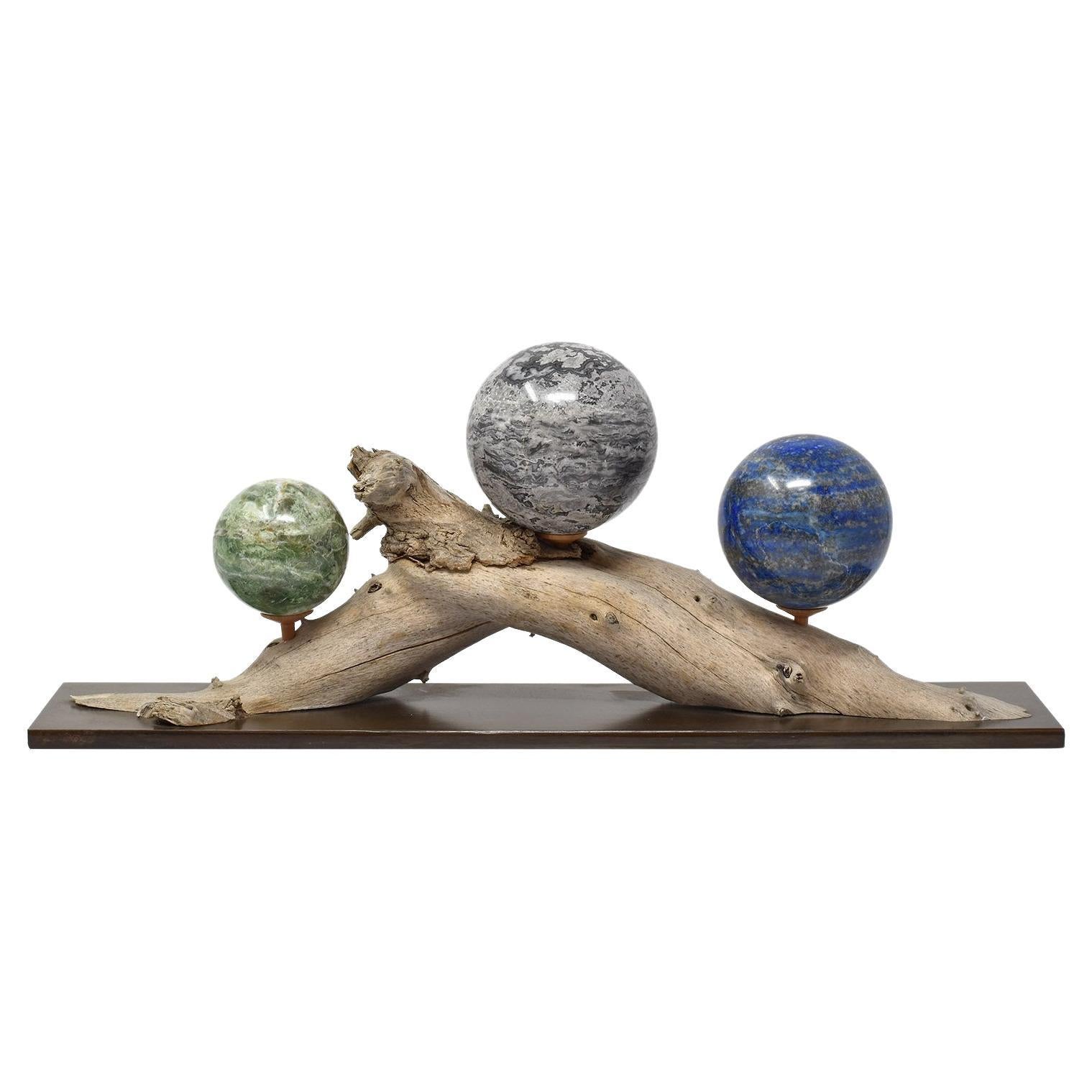 Three Mineral Spheres Mounted on an Organic Wood Branch