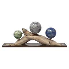 Three Mineral Spheres Mounted on an Organic Wood Branch