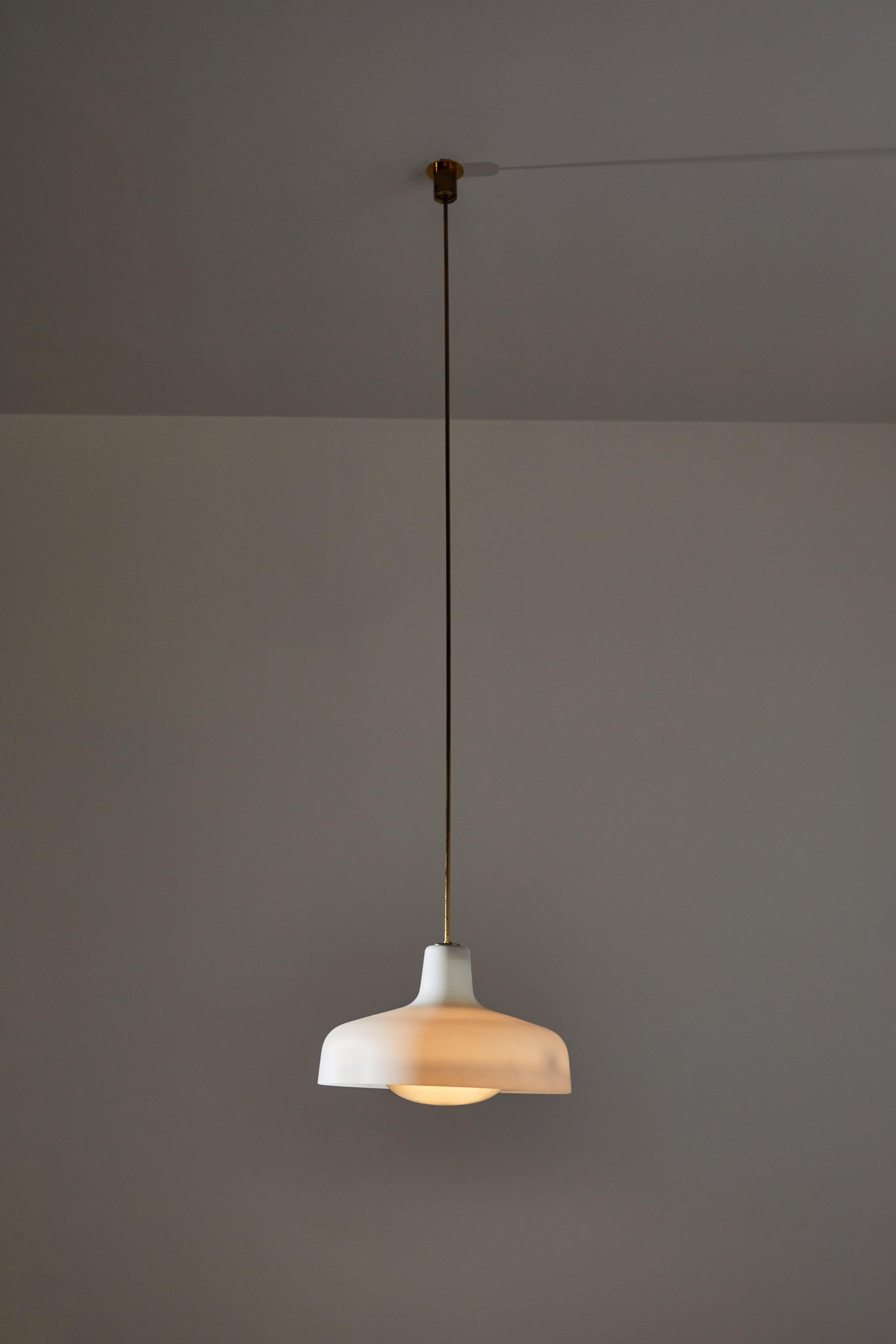 Three Model LS7 Paolina pendant by Ignazio Gardella for Azucena. Designed and manufactured in Italy, 1958. Brass, glass. Original canopies and custom brass ceiling plate. We recommend one E27 75 watt maximum bulb. Single bulb provided as a one time