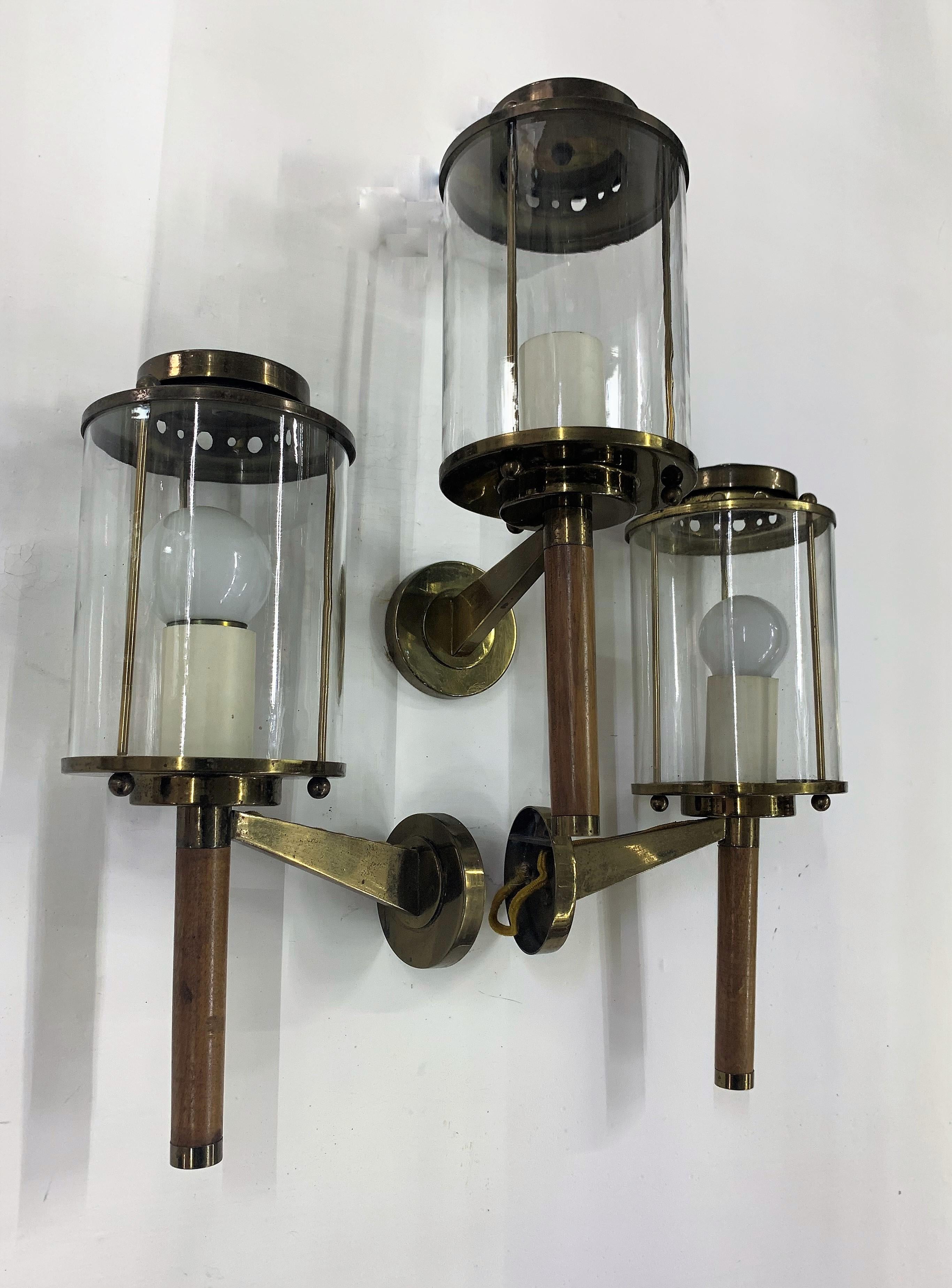 Pair of Mid-Century Modern sconces or wall lights attributed to Maison Arlus in brass, wood (teak?) and clear glass.
Made in France, circa 1950s.
The sconces still had the original fabric electric cable (last photographs) but they have been