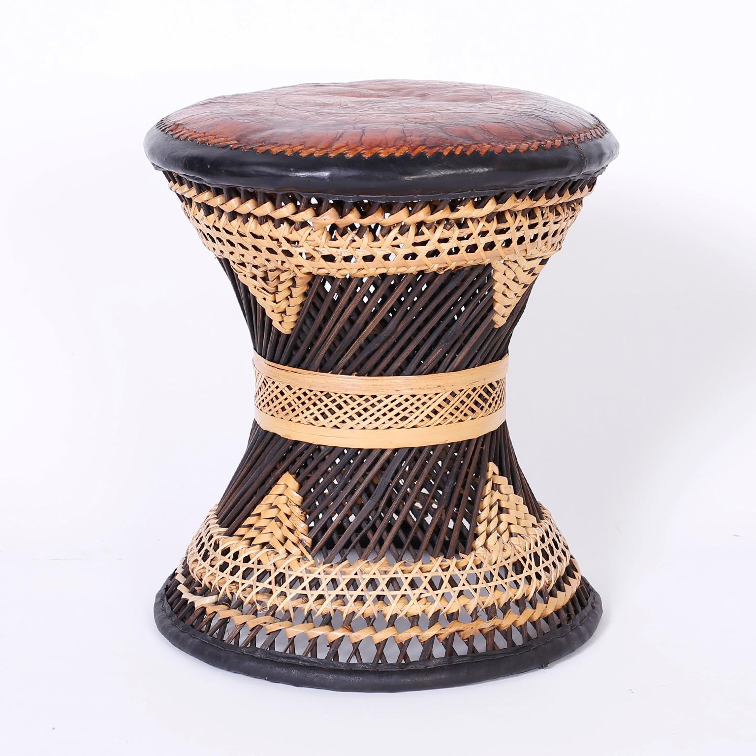 Three Moroccan stools with lush brown leather tops aged to perfection. The bases are crafted in stick wicker and decorated with reed wrapped in geometric designs. Priced Individually.