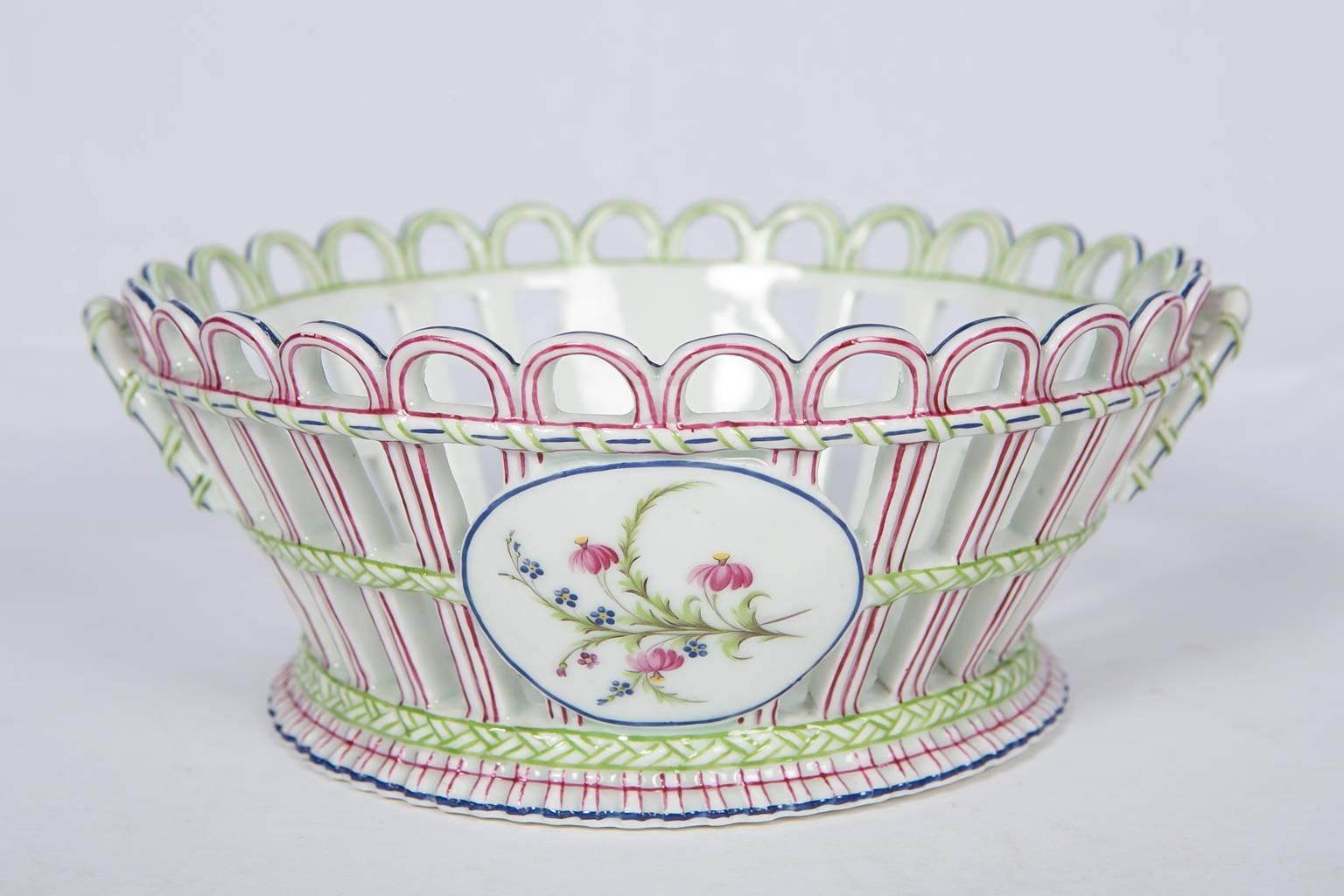 We are pleased to offer this set of three antique Niderviller porcelain open-work baskets. Made in France circa 1800, the open-work baskets are decorated with delicate, feminine flowers painted deep pink, soft green, and blue. Each basket has two