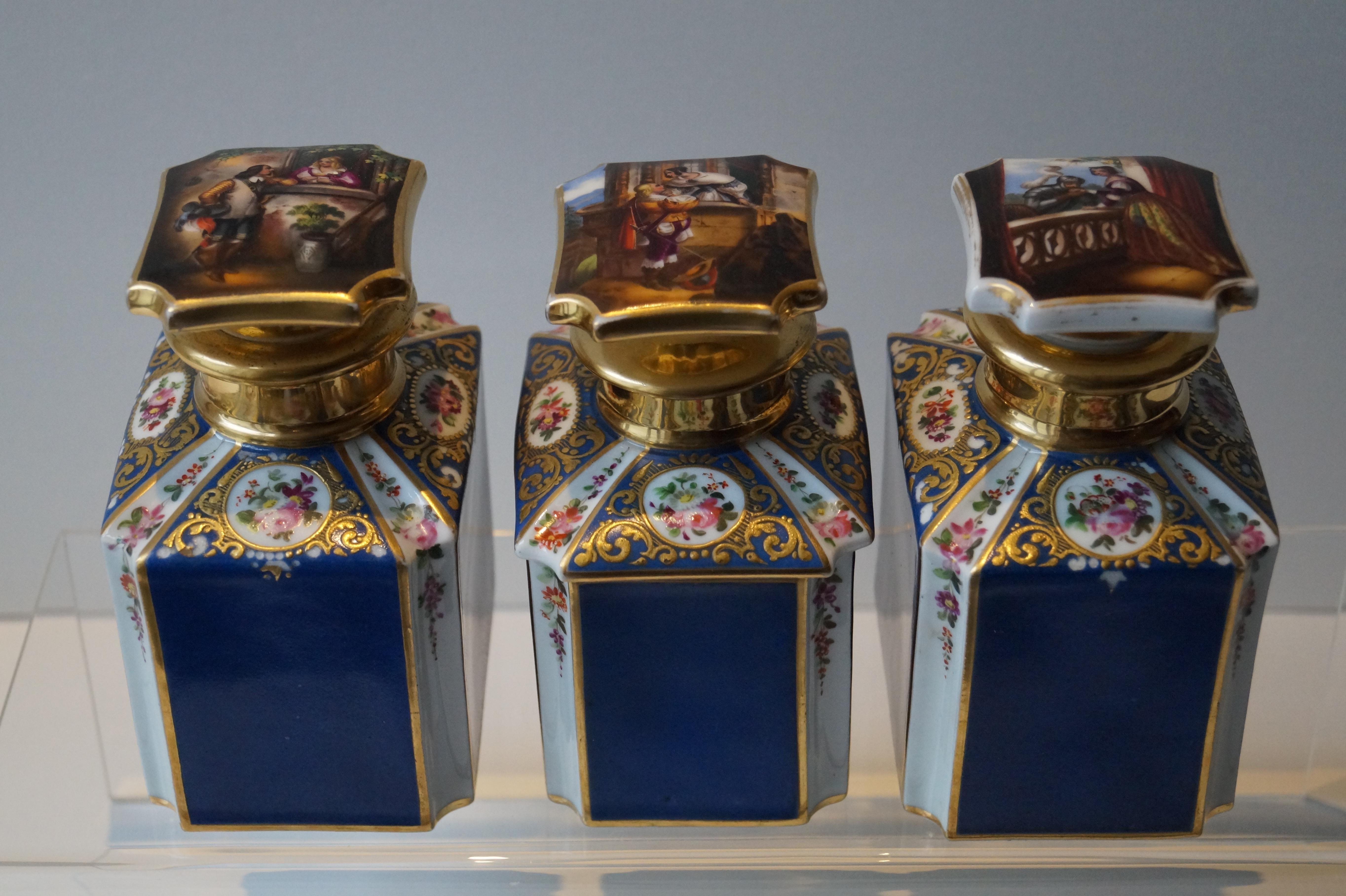 Three beautiful rare tea caddies richly decorated with gold and panels with flowers.

On the top of the lids three different hand painted images of couples in love.

Excelent wedding gift!

Good condition. Some wear consistent of