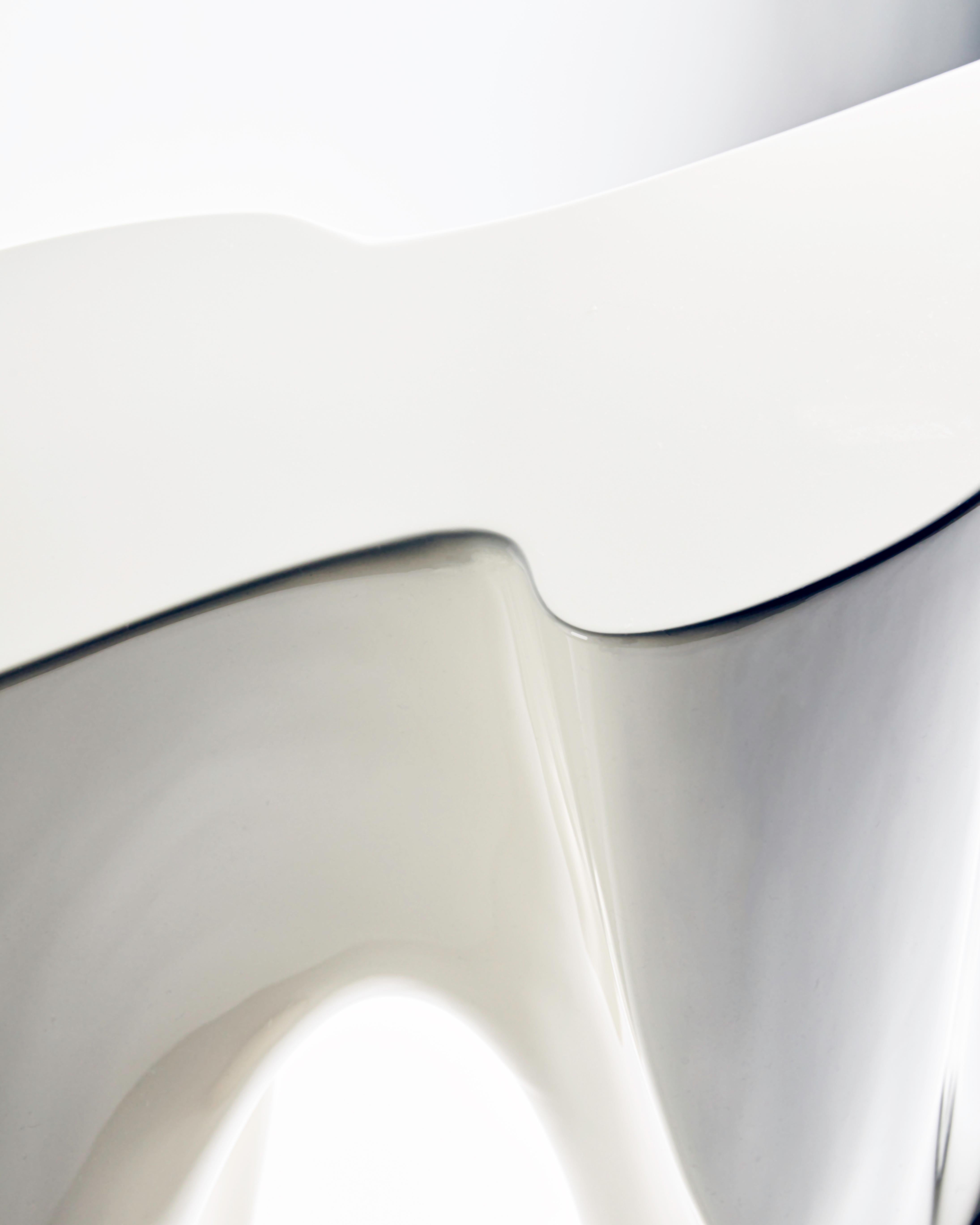 The Neolithic console table stands confidently in high gloss cream lacquer. 
Taken from the Holocene master but pulled, manipulated and sliced across parallel planes in CAD after being 3D scanned to give function to this bold sculptural statement