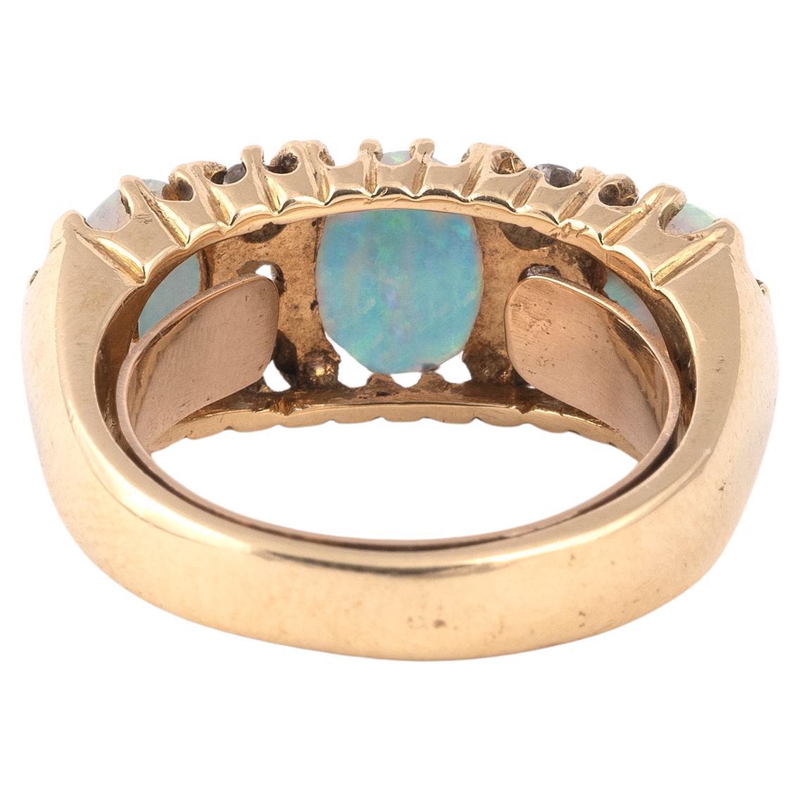 An Edwardian opal and diamond half hoop ring, set with three opal cabochons and six old circular-cut diamonds in yellow gold
Size 7 
Weight: 8,5gr.