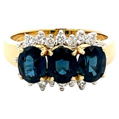 Bague à trois saphirs bleus ovales et diamants en or jaune 18 carats