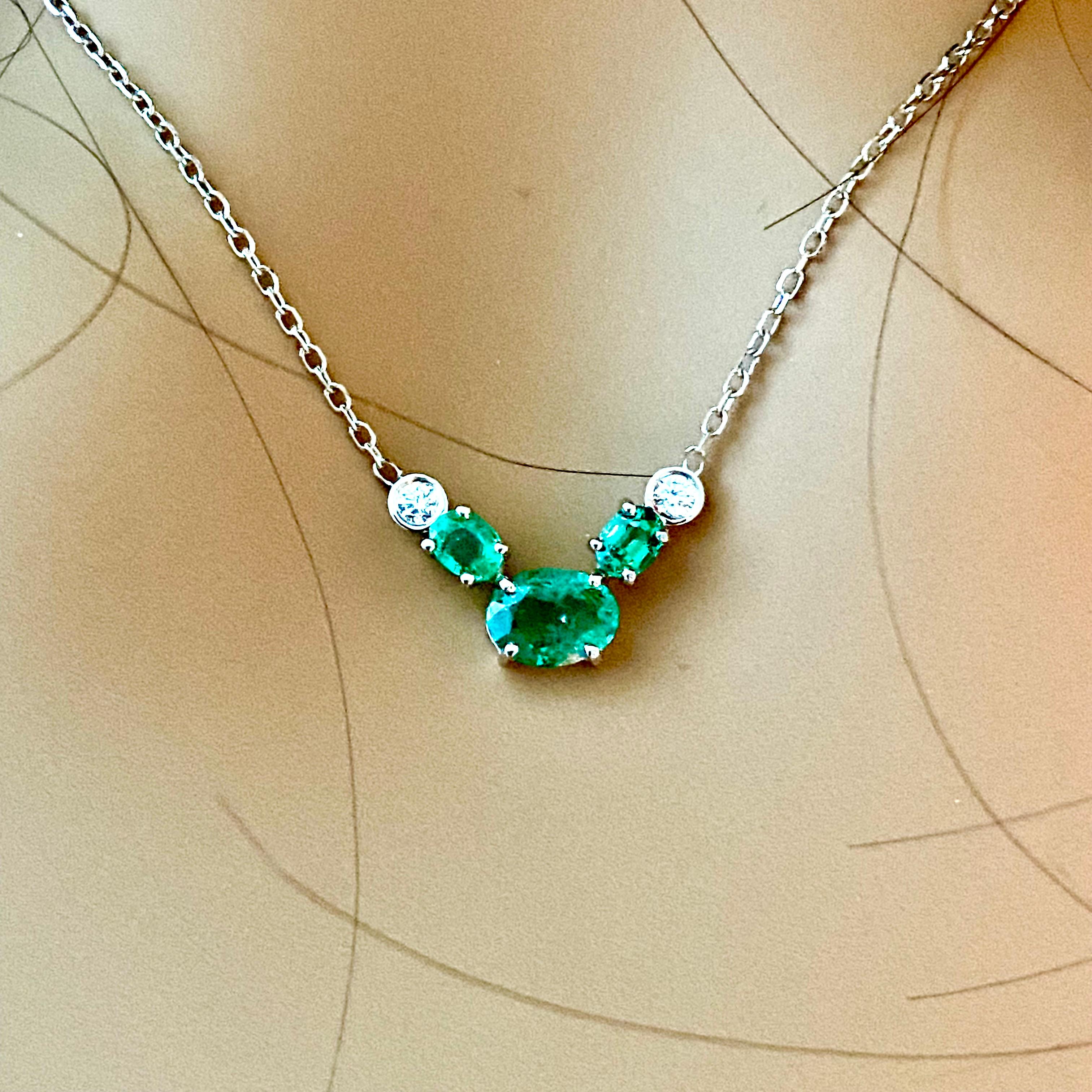 Fourteen karats white gold necklace pendant with emerald
Necklace measuring 16.80 inch and 0.45 inch wide
Oval-shaped emerald weighing 0.80 carats set in white gold setting 
Two oval emeralds weighing 0.50 carats set in white gold setting 
Two round