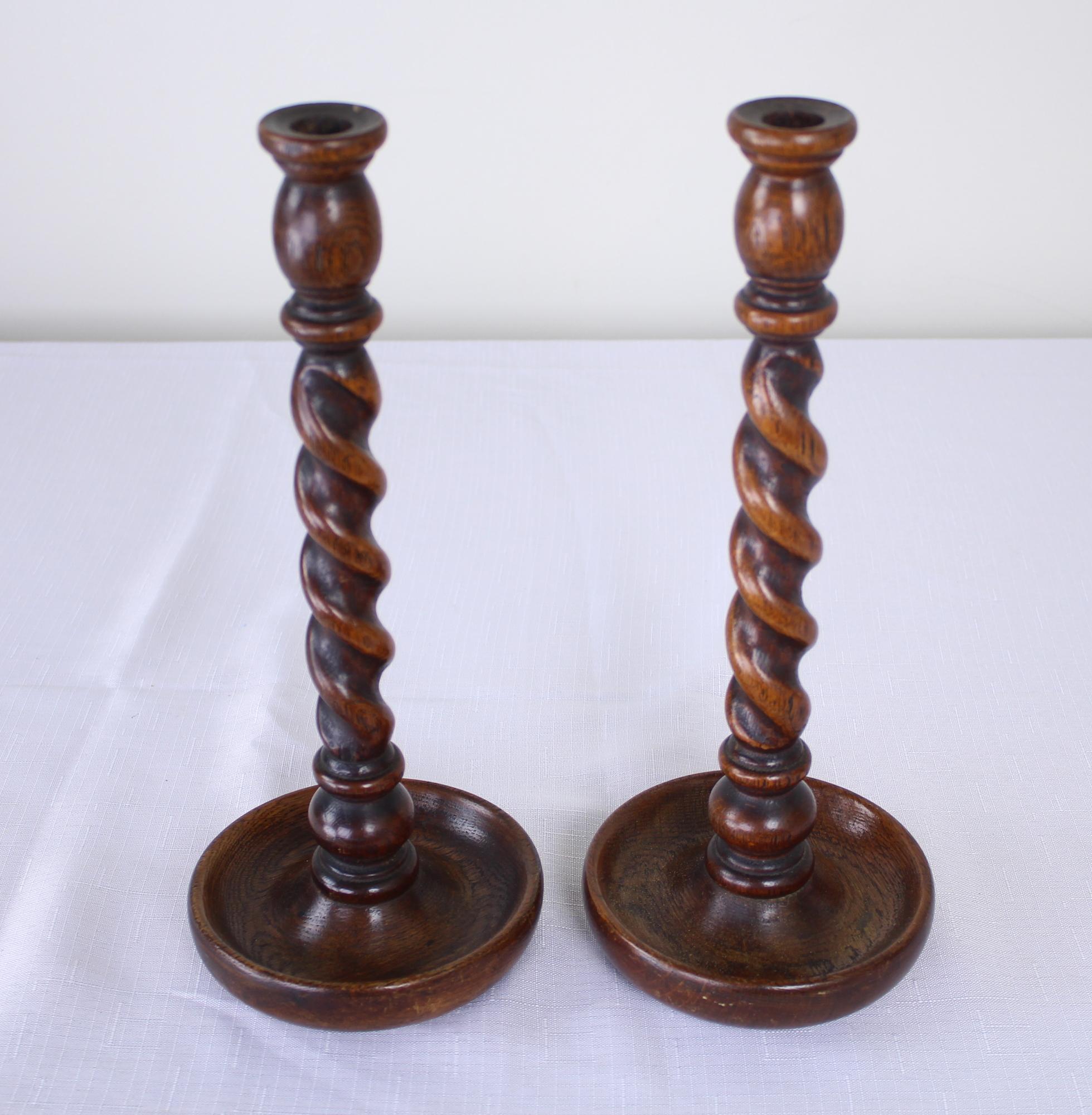 A small collection of oak candlesticks, England, circa 1900. Heights vary from 11-13