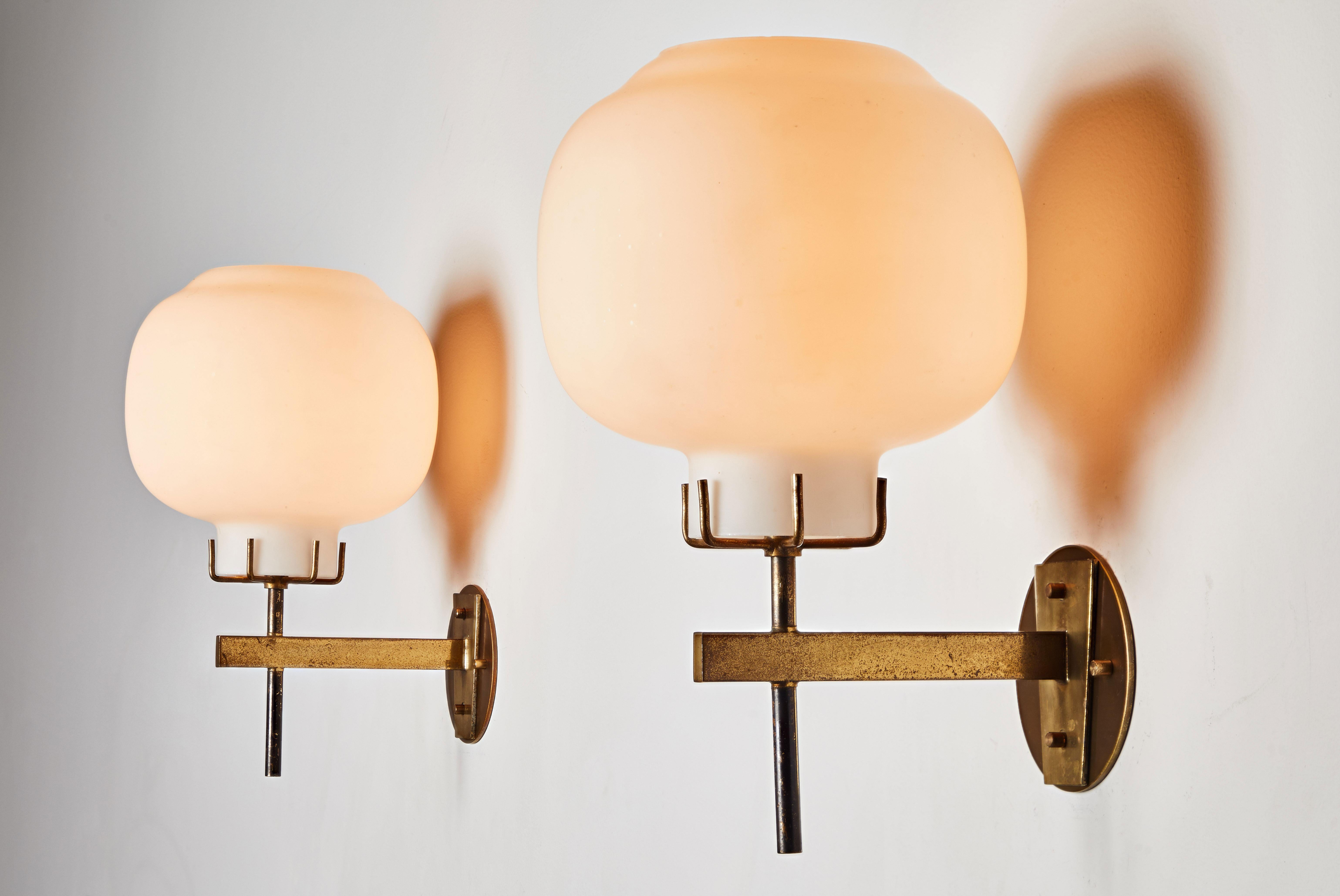 One Pair of sconces by Stilnovo. Manufactured in Italy, circa 1950s. Wired for US junction boxes. Brass and brushed satin glass. Each sconce takes one E27 100w maximum bulb. Retains original manufacturer's label. Sold as pairs only. Quantity 2