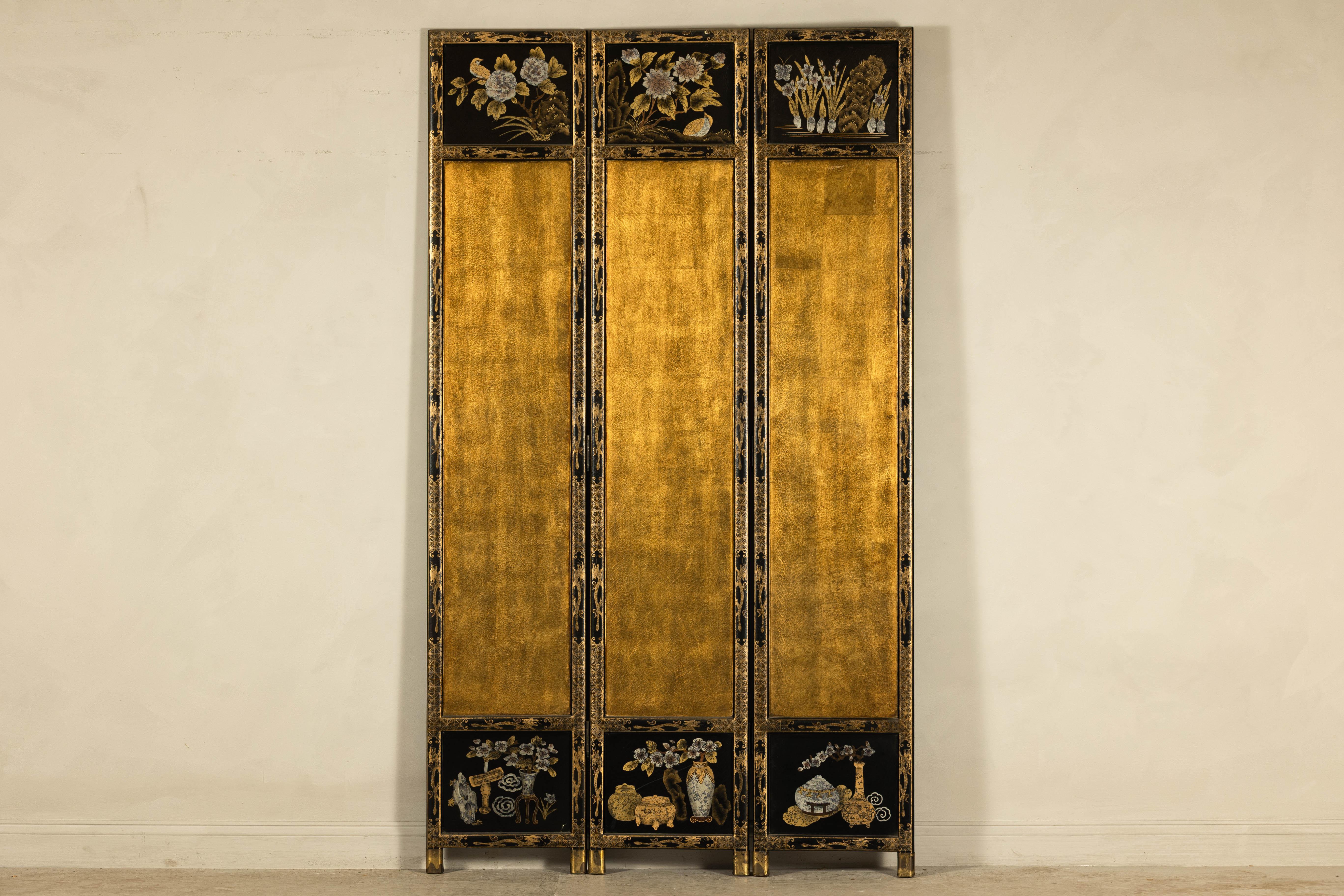 This three-panel Chinese screen brings together classic lacquer artistry and poetic detail in a visually striking vertical format. The front side is clad in luminous gold leaf with hand-painted still life motifs at the top and bottom of each panel,