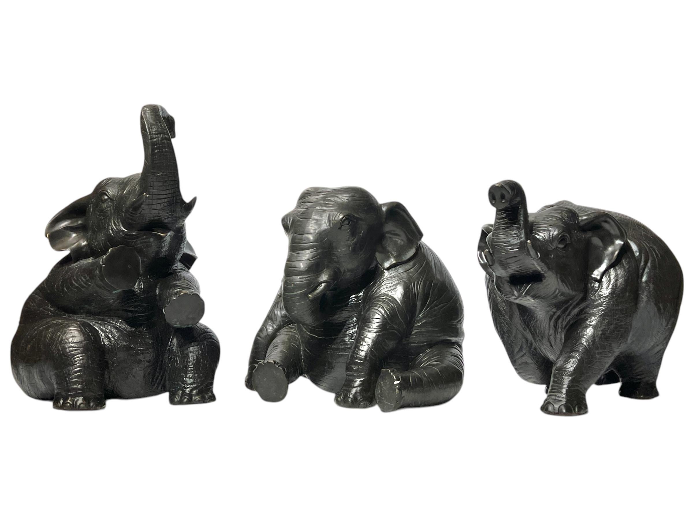 Collezione di tre grandi elefanti in bronzo con patina marrone scuro, che misurano 12-16 pollici di altezza, 10-12 di larghezza e 14-20 di profondità.  Apparentemente non firmato.