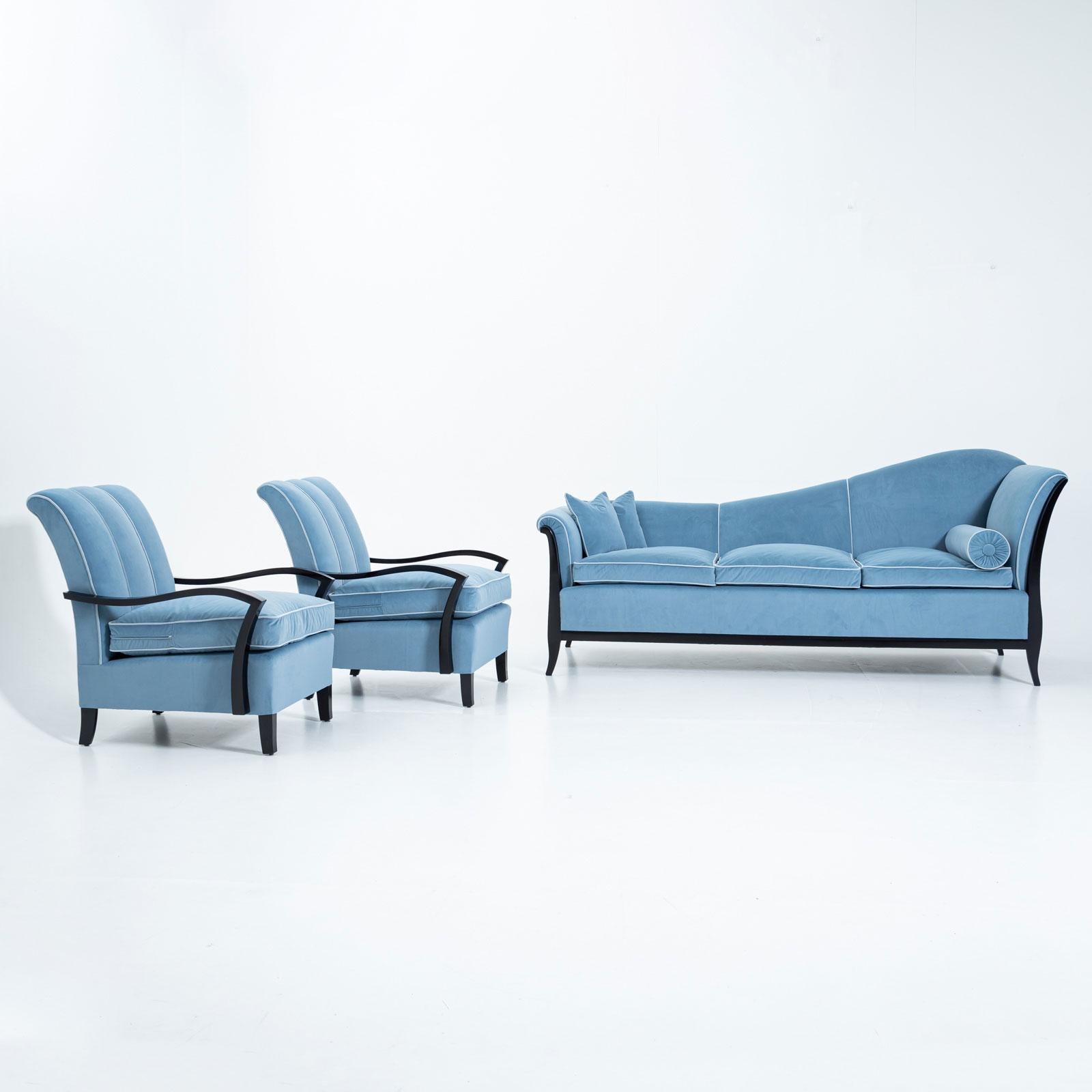 Un élégant ensemble de trois pièces Art déco composé d'un canapé et de deux chaises longues avec des cadres ébonisés. Le canapé est doté d'un dossier arrondi qui s'élève gracieusement vers la droite et a été récemment revêtu d'un velours bleu clair